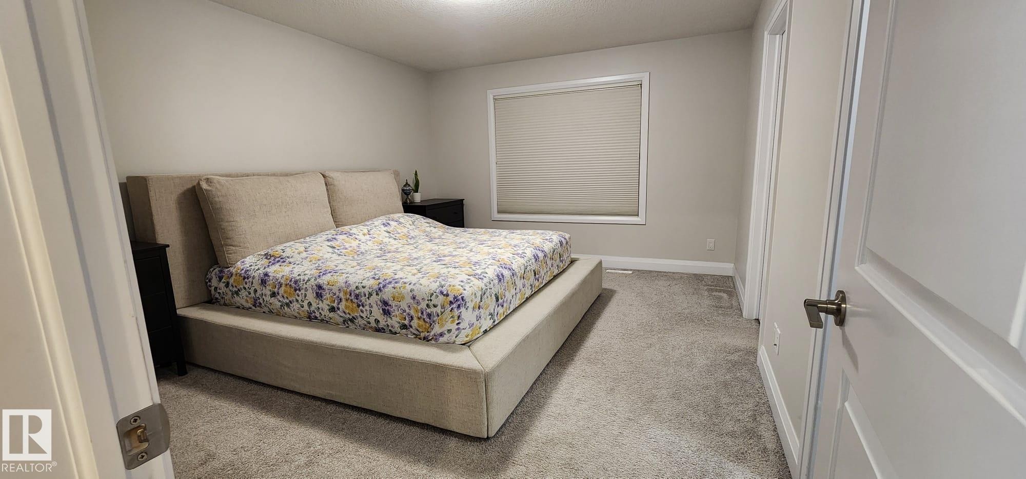 Neutral wall paint, ceiling-mounted lighting, white trim, and a window with a roller shade - 3779 Cherry Loop Sw, Edmonton, AB