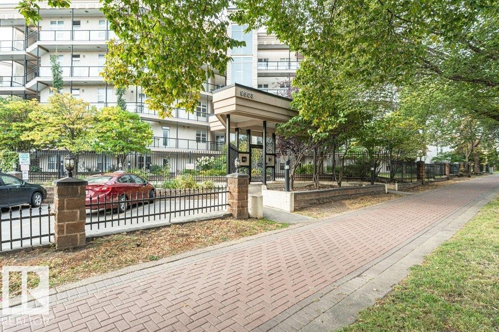 Brick paver walkway with a black iron fence and brick pillars - #202 9503 101 Av Nw, Edmonton, AB