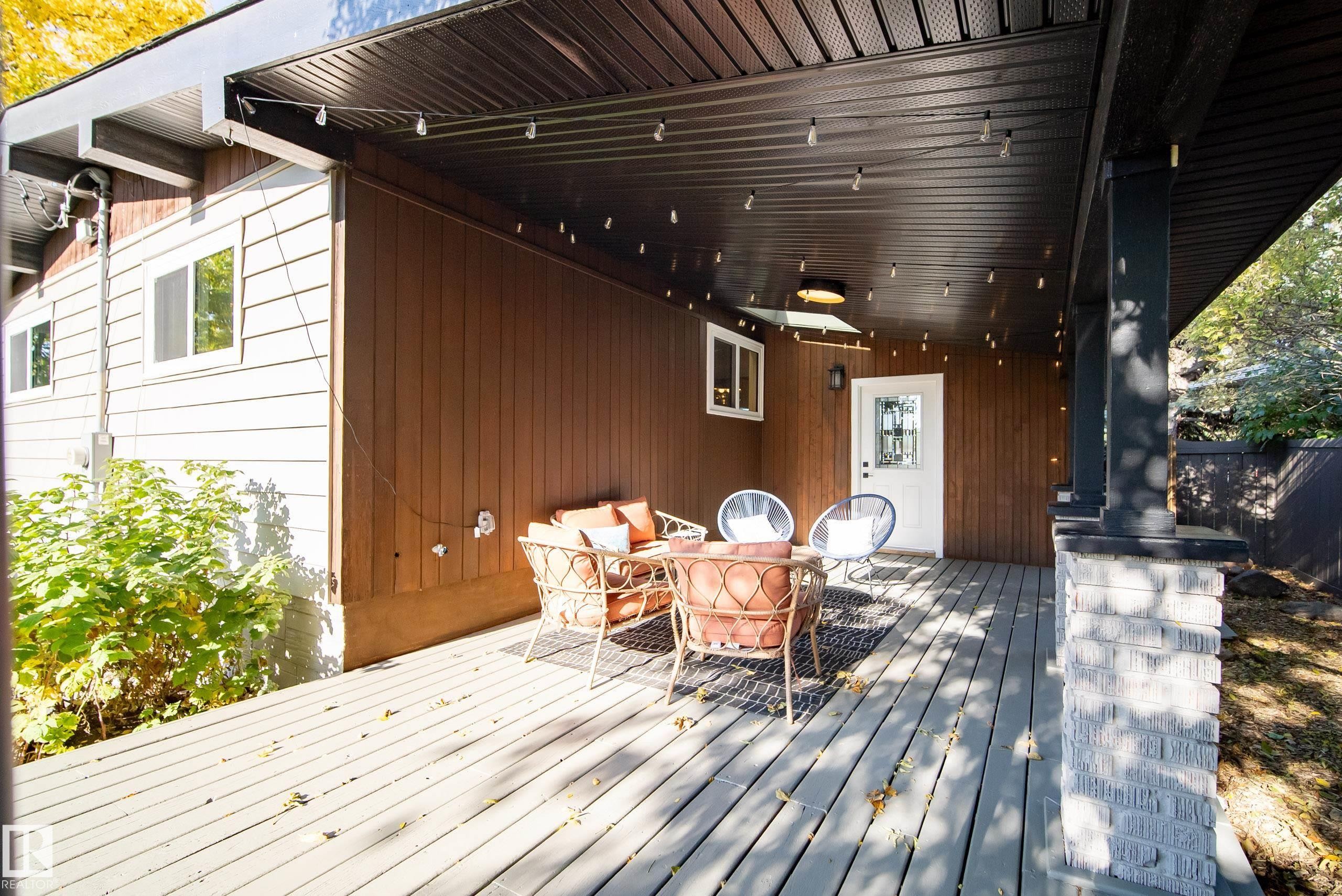 Covered porch with wood-finish decking, dark brown ceiling, and brick base column - 10316 42 Street Nw, Edmonton, AB