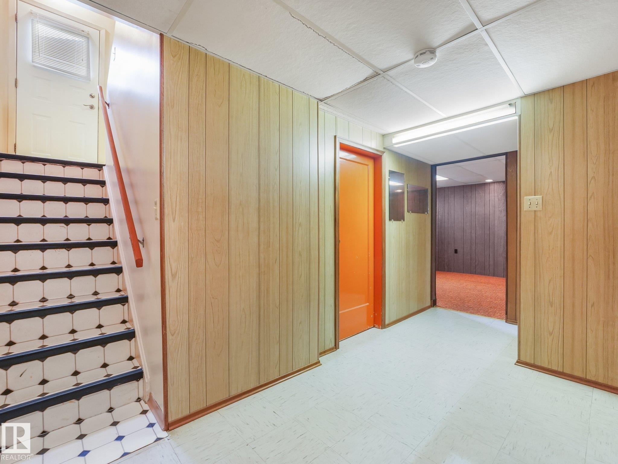 Staircase with patterned tile risers and a wood handrail - 5904 94 Avenue Nw, Edmonton, AB