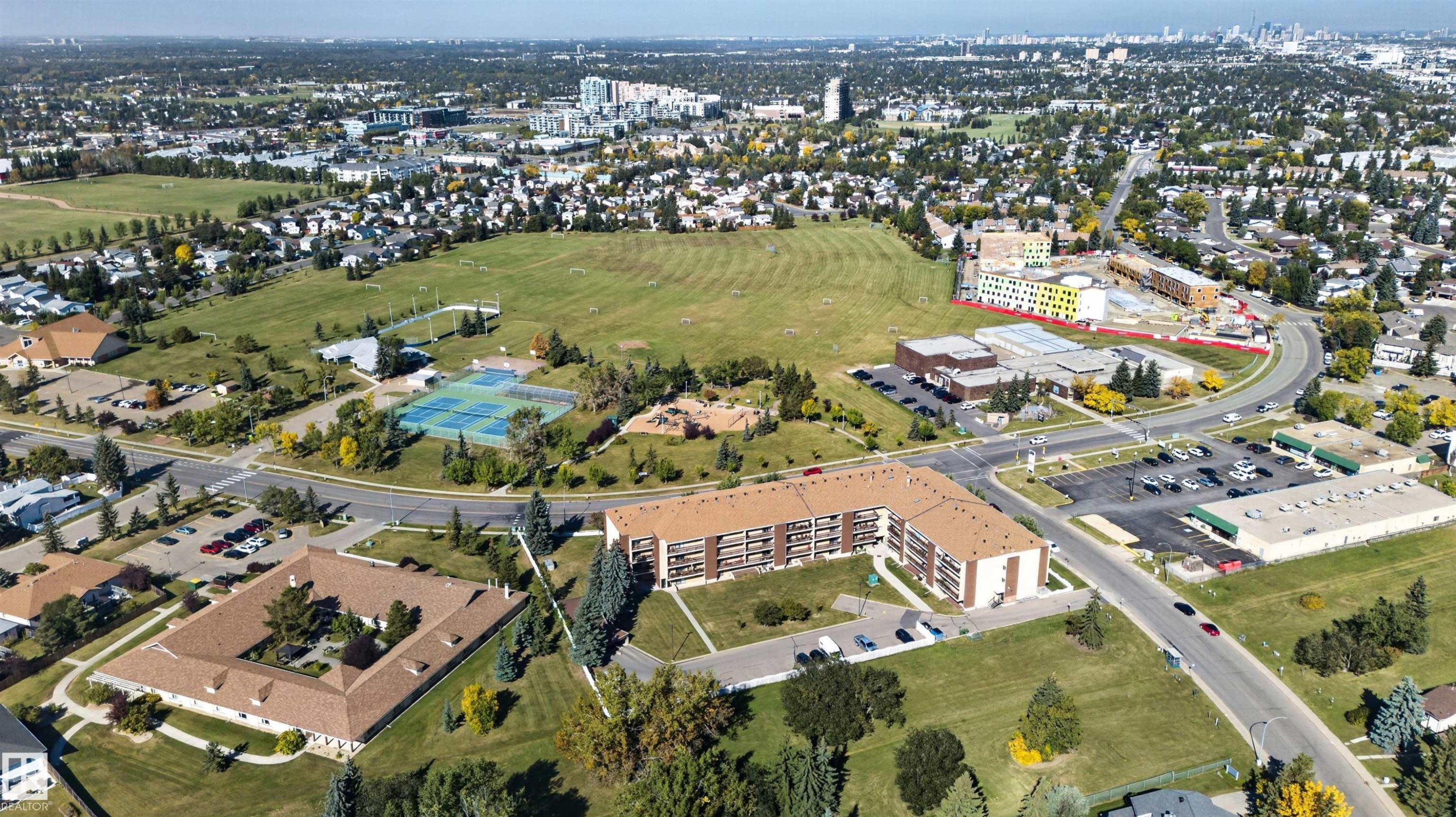 Expansive suburban landscape with varied residential structures, abundant green spaces, a commercial building complex, and multiple roadways - 1519 104 Street Nw, Edmonton, AB