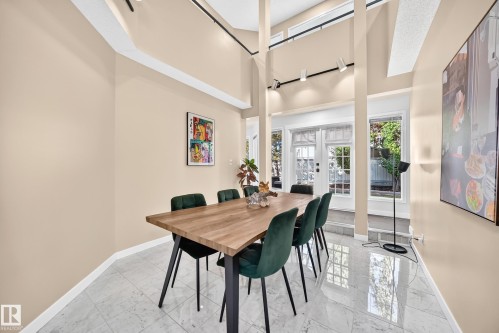 Vaulted ceilings with track lighting, polished tile flooring, and large windows with transom panels - 5830 181 Street Nw, Edmonton, AB 