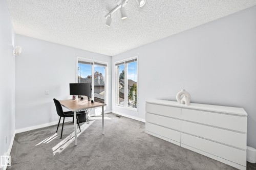 Bright room with two large windows, track lighting, and wall-mounted sconces - 5830 181 Street Nw, Edmonton, AB 
