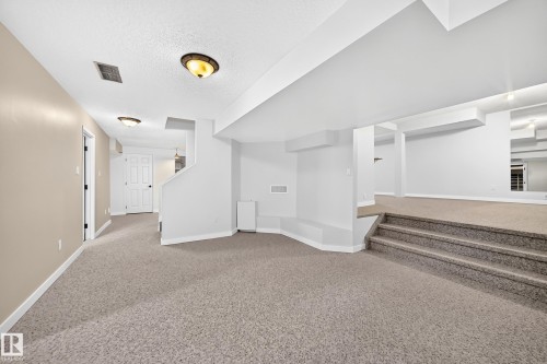 Carpeted flooring throughout, recessed lighting, and a neutral color palette - 5830 181 Street Nw, Edmonton, AB 