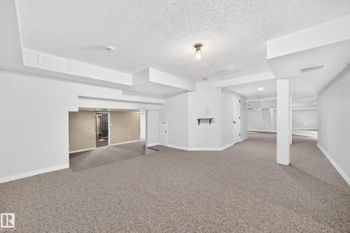 Spacious lower level with neutral carpet, white painted walls, and recessed lighting - 5830 181 Street Nw, Edmonton, AB 
