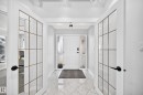 Foyer featuring patterned tile flooring and a solid panel entry door with frosted glass sidelights - 5830 181 Street Nw, Edmonton, AB 