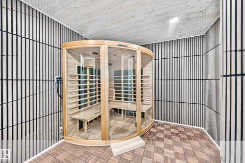 Built-in sauna with wood and glass enclosure, slatted wood-finish wall panels, wood-finish ceiling, and wood-finish tile flooring - 5830 181 Street Nw, Edmonton, AB 