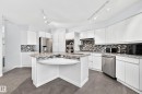 Kitchen featuring white cabinetry, granite countertops, stainless steel appliances, a mosaic tile backsplash, and track lighting - 5830 181 Street Nw, Edmonton, AB 