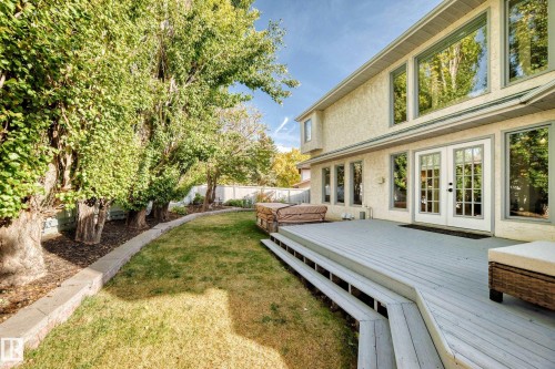 Rear stucco exterior with multiple large windows and French doors - 5830 181 Street Nw, Edmonton, AB 
