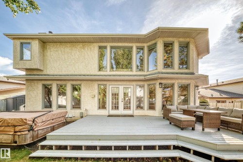 Rear exterior featuring a multi-level deck, stucco finish, and extensive window placement - 5830 181 Street Nw, Edmonton, AB 