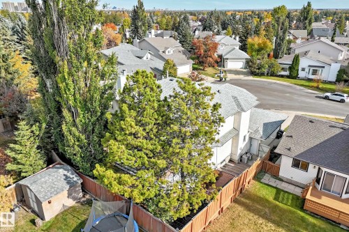Detached property with a light-colored exterior, an attached shed, and a wooden fence enclosing a lawn area - 5830 181 Street Nw, Edmonton, AB 