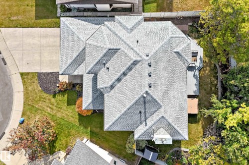 Multiple rooflines with asphalt shingles, expansive paved driveway, and mature landscaping - 5830 181 Street Nw, Edmonton, AB 