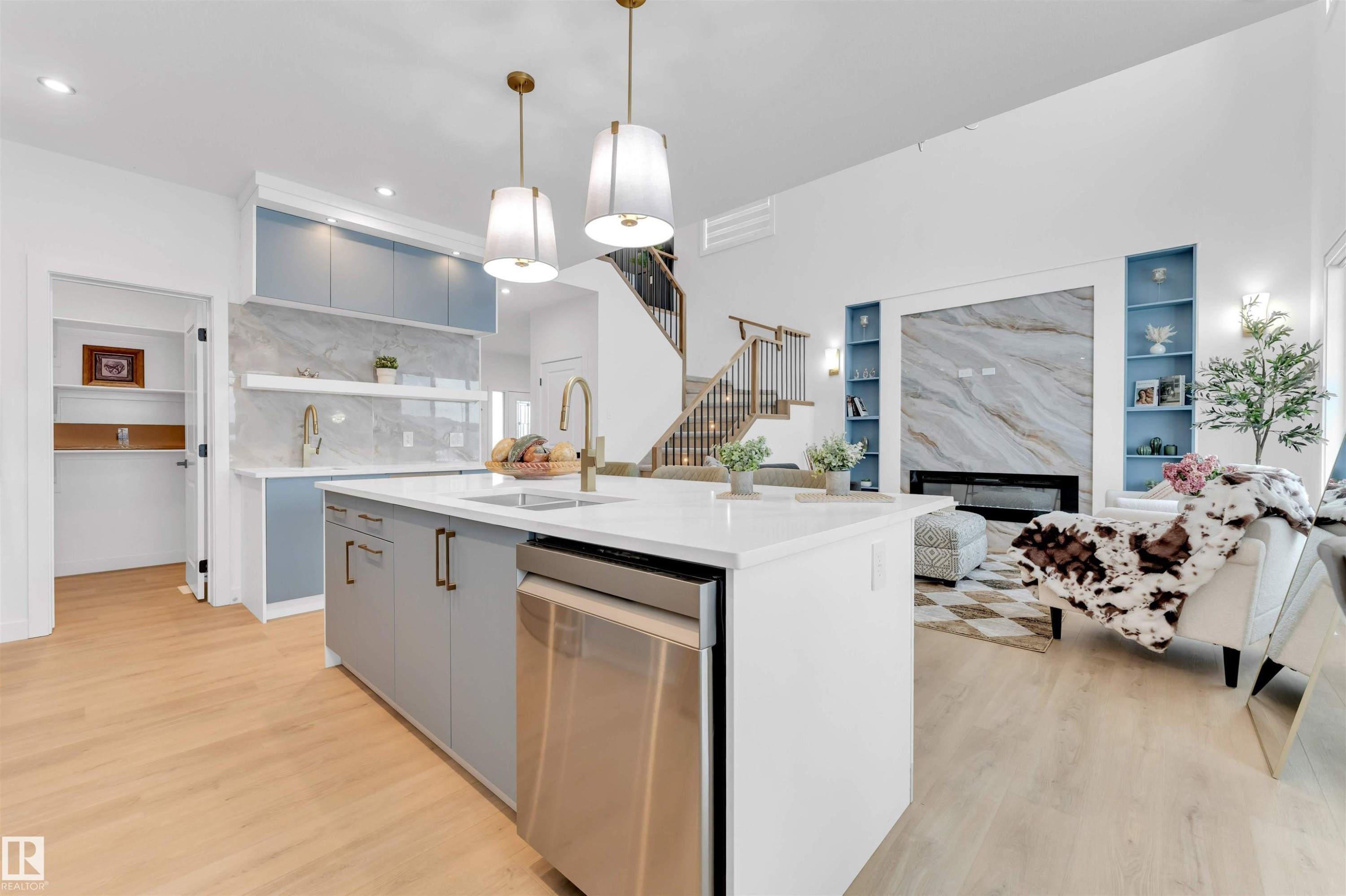 Kitchen island with an undermount sink and a stainless steel dishwasher - 2 Tenuto Link, Spruce Grove, AB
