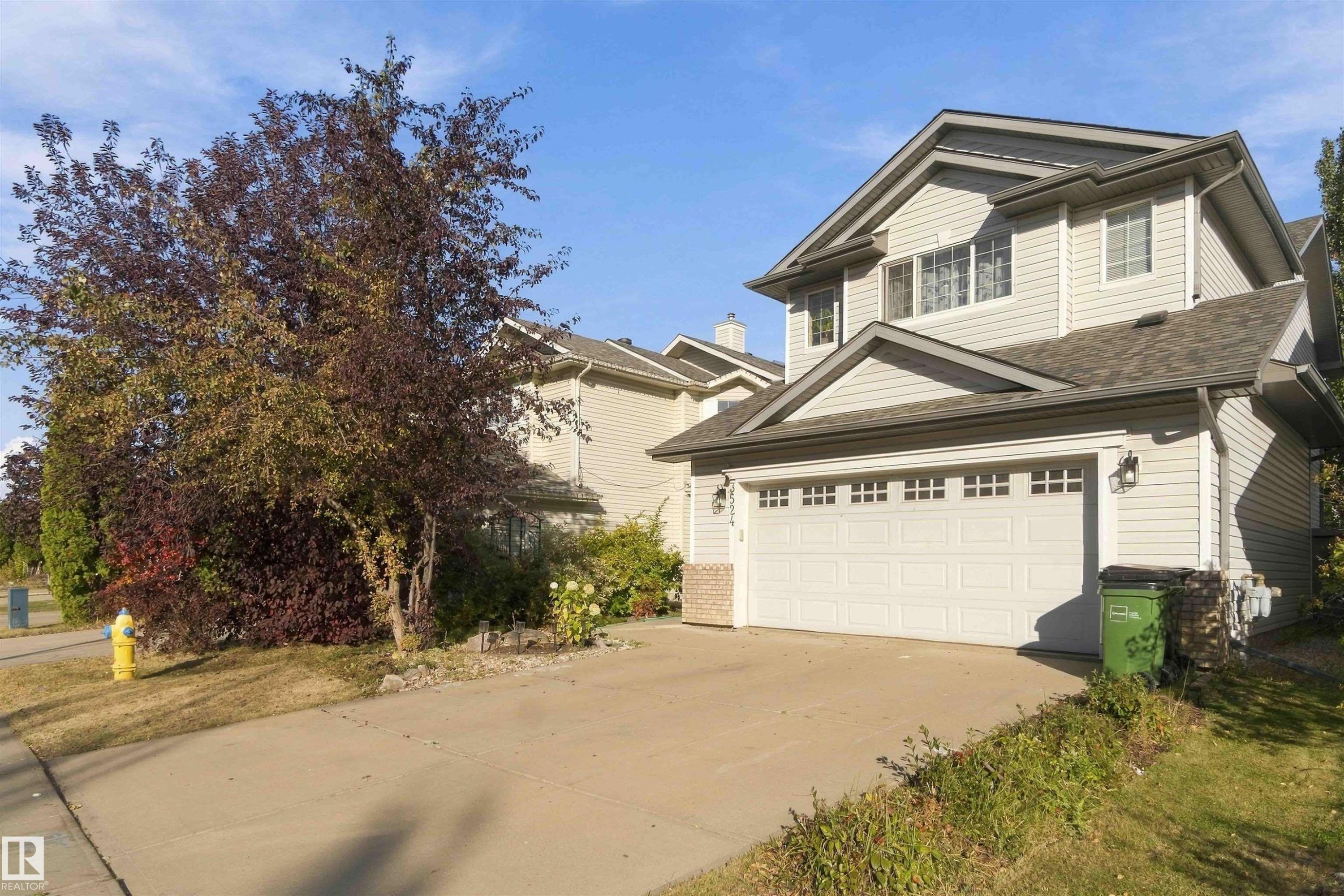 Two-story residence with light-colored siding, an attached two-car garage, and a concrete driveway - 3524 Mclean Crescent Sw, Edmonton, AB