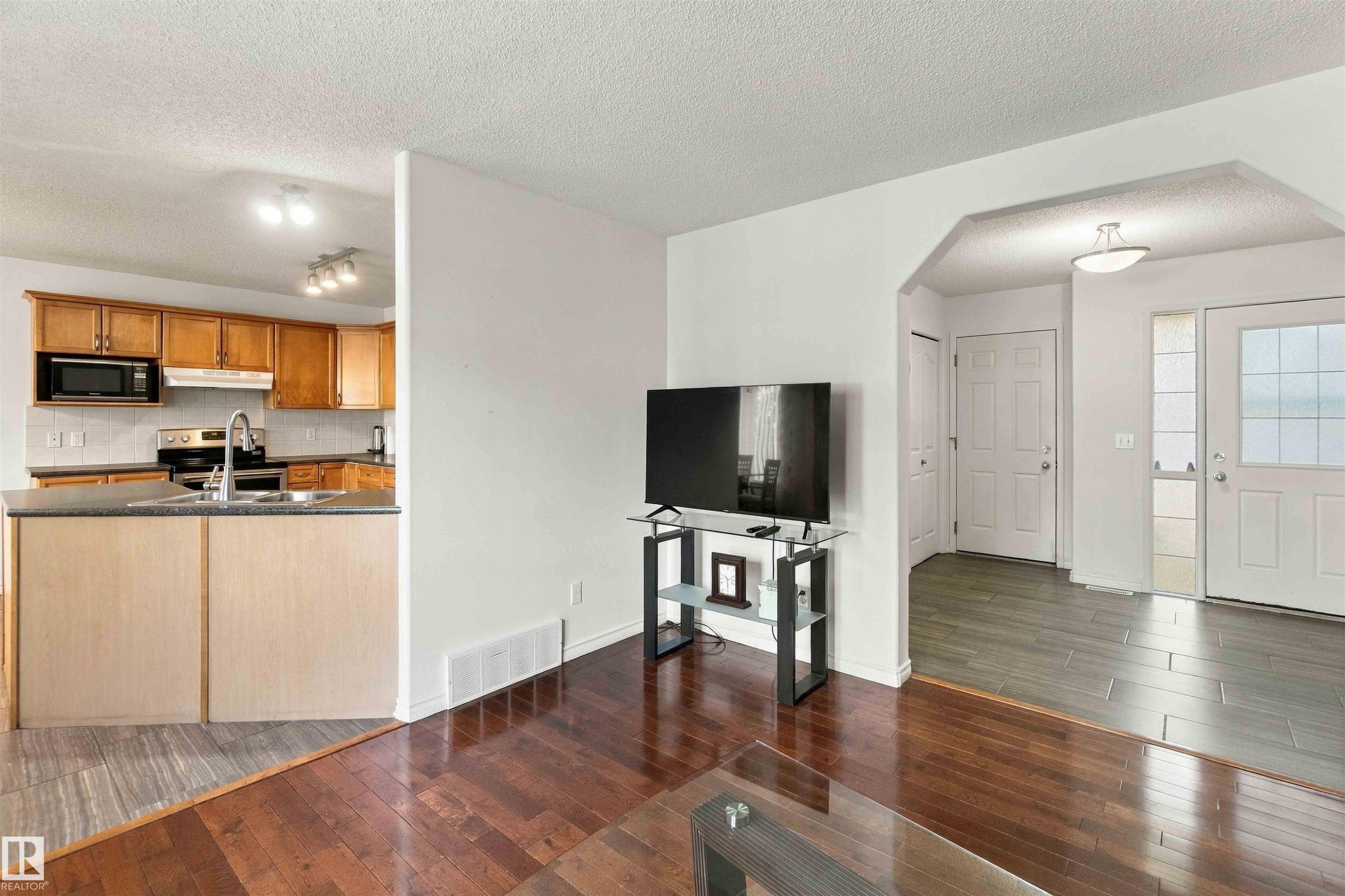 Open-concept living area with dark wood-finish flooring - 3524 Mclean Crescent Sw, Edmonton, AB