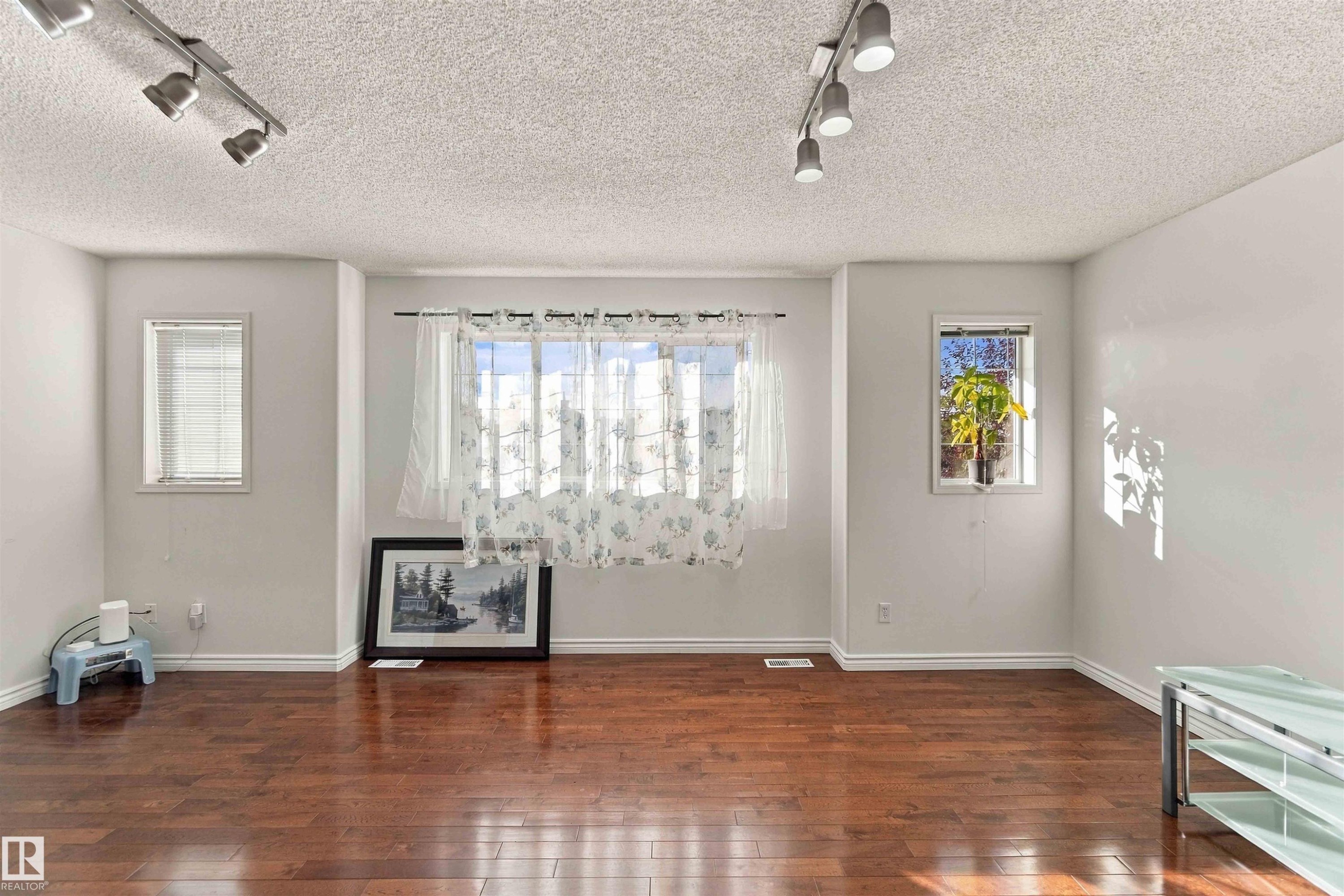 Rich wood-finish flooring with white baseboards throughout - 3524 Mclean Crescent Sw, Edmonton, AB