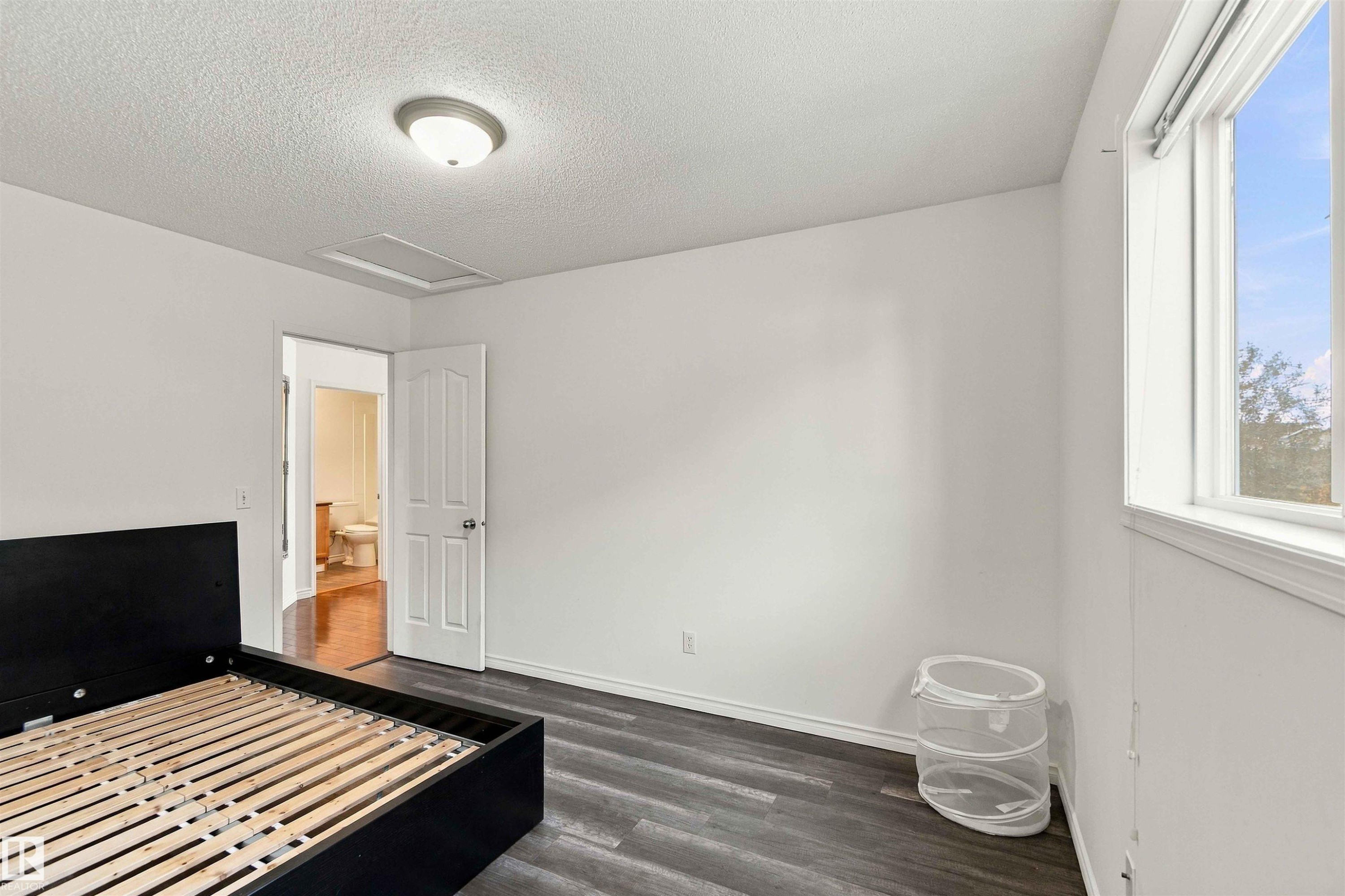 Wood-finish flooring, white walls, and a single window with a white frame - 3524 Mclean Crescent Sw, Edmonton, AB