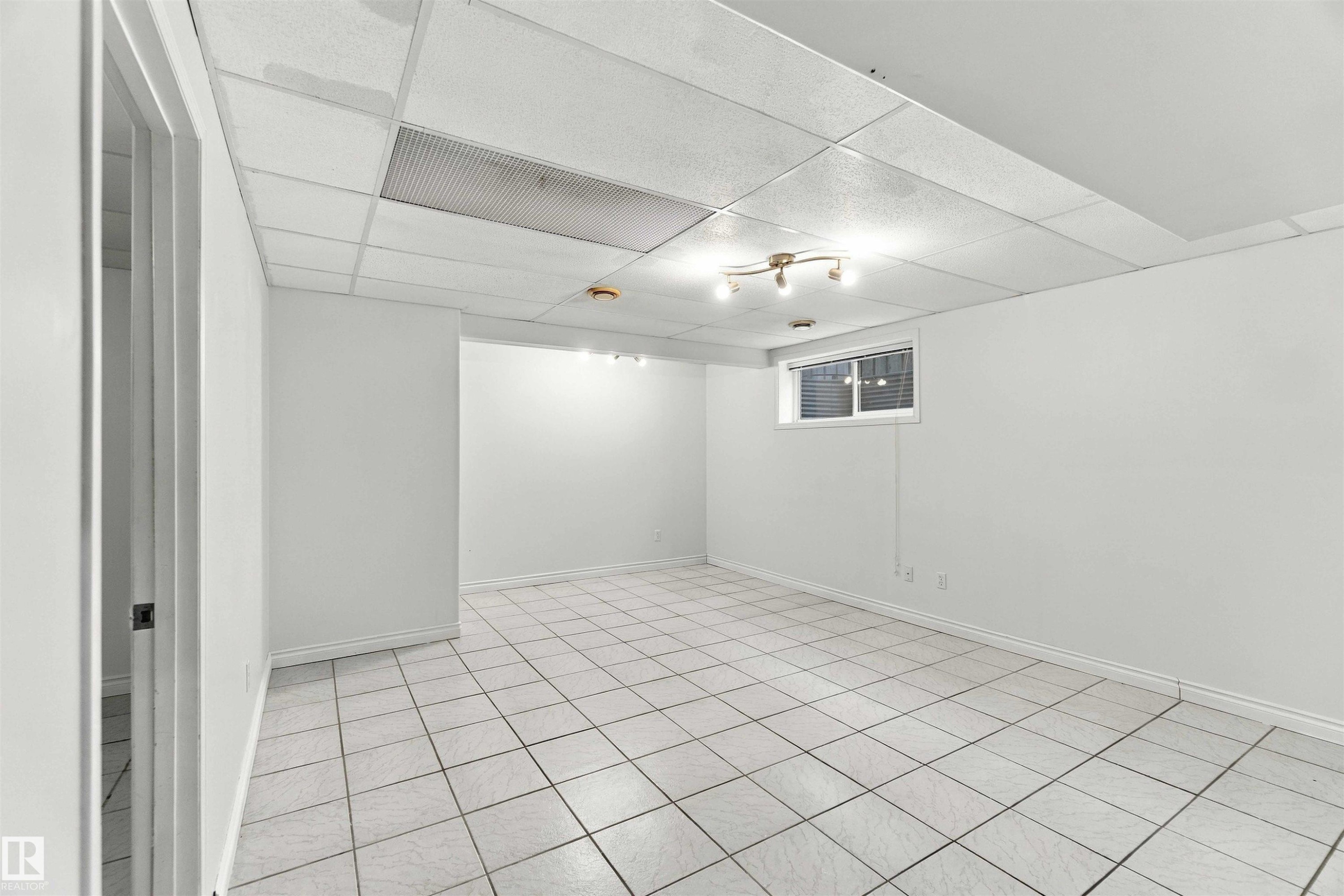 White ceramic tile flooring, drop ceiling with integrated lighting, recessed window, and white painted walls - 3524 Mclean Crescent Sw, Edmonton, AB
