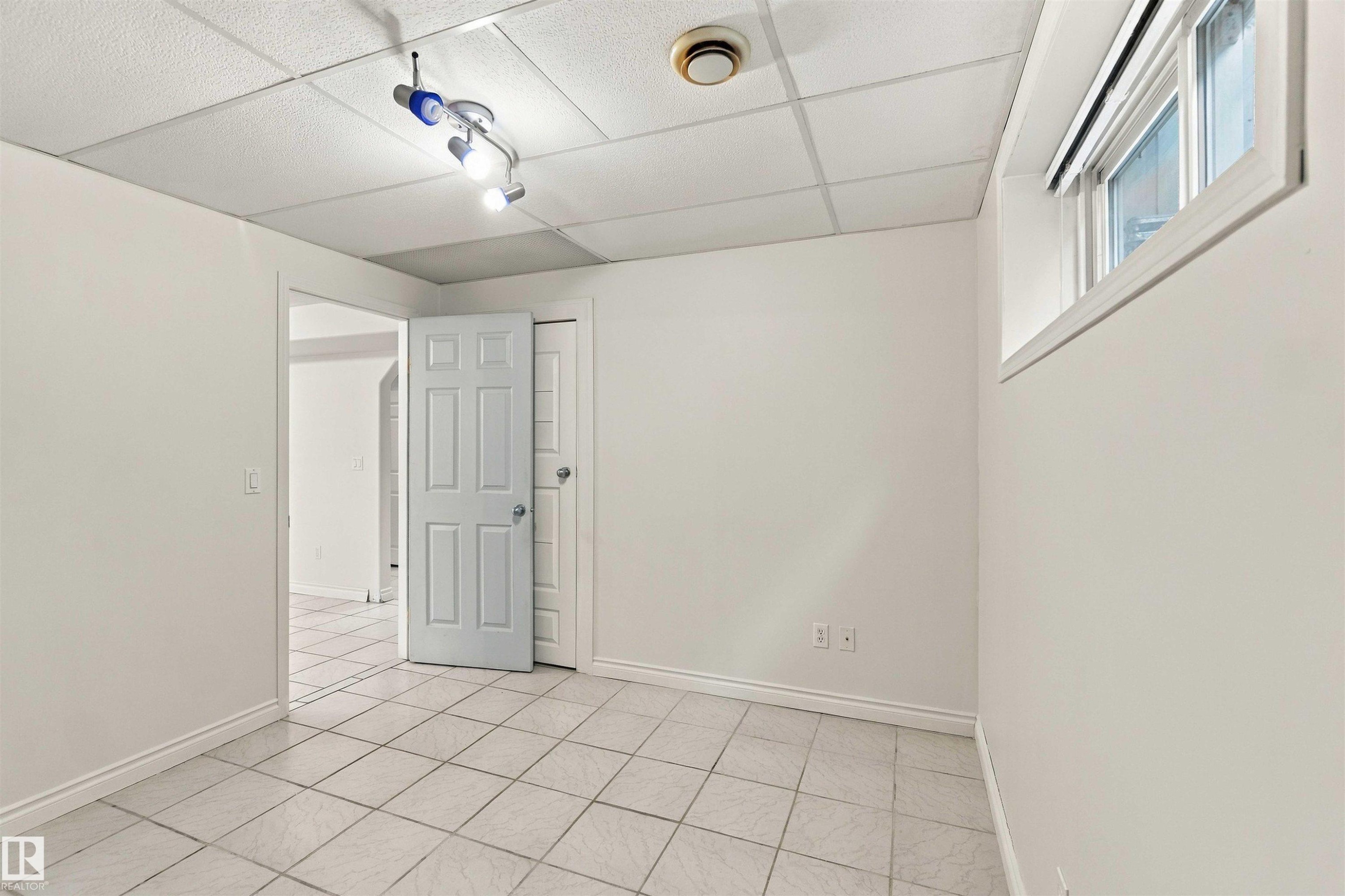 White tiled flooring, white painted walls, white framed window, square panel ceiling, track lighting fixture - 3524 Mclean Crescent Sw, Edmonton, AB