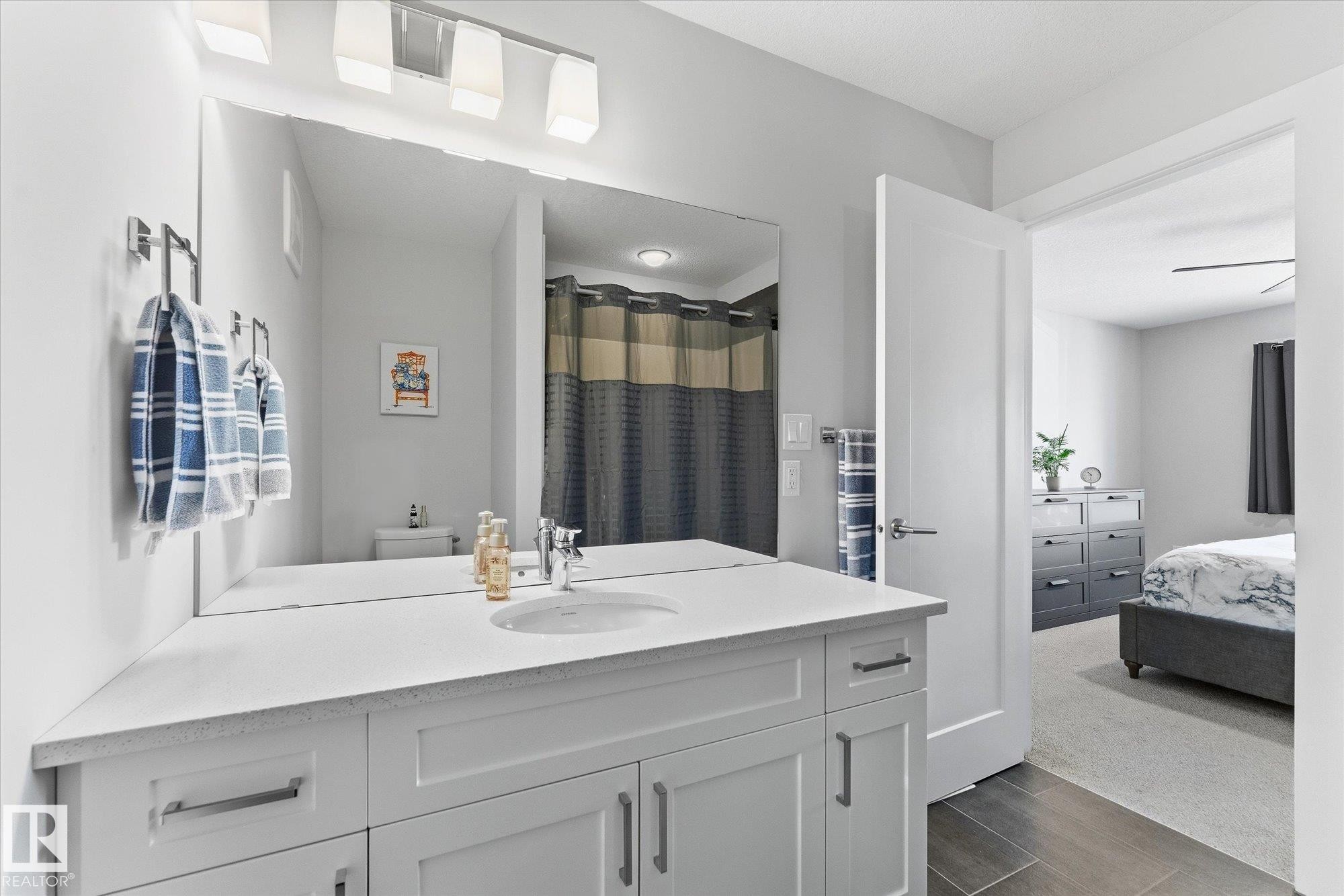 Bathroom vanity with integrated sink, expansive mirror, and chrome fixtures - #15 4835 Wright Dr Sw, Edmonton, AB
