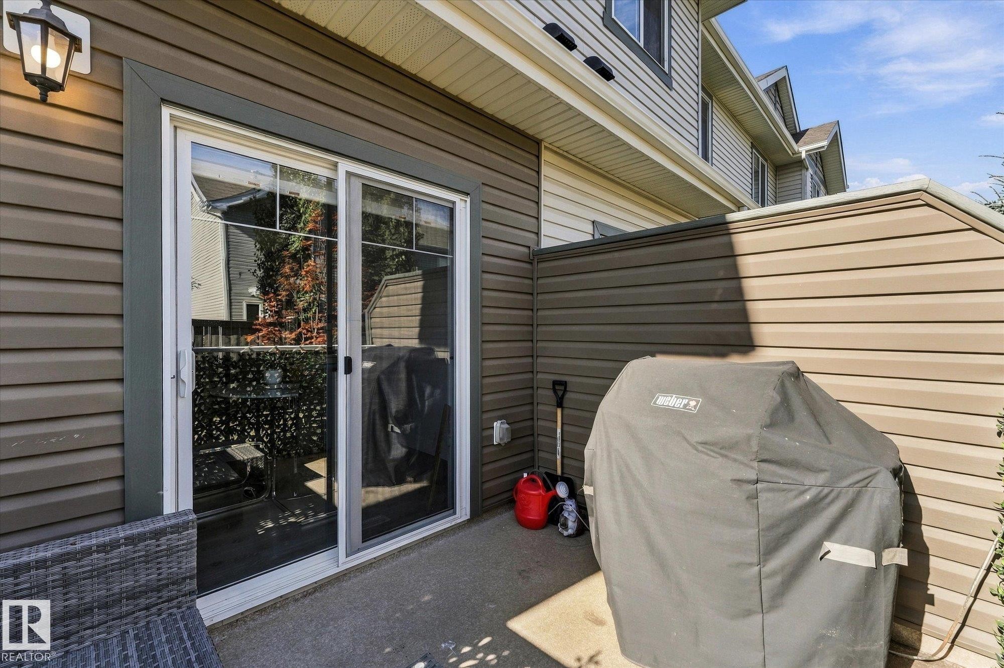 Paved patio area featuring durable siding and a permanent privacy wall - #15 4835 Wright Dr Sw, Edmonton, AB