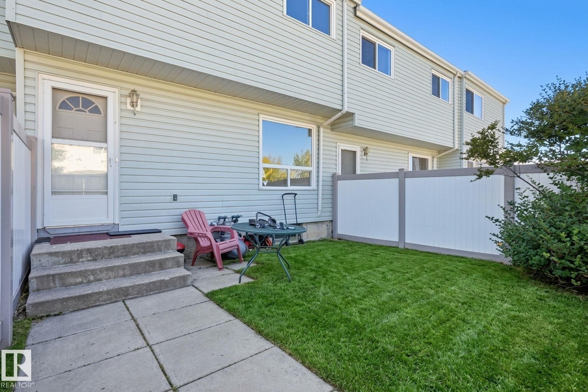 Private outdoor space with a manicured lawn, concrete patio, and privacy fencing - 164 Dickinsfield Court Nw, Edmonton, AB