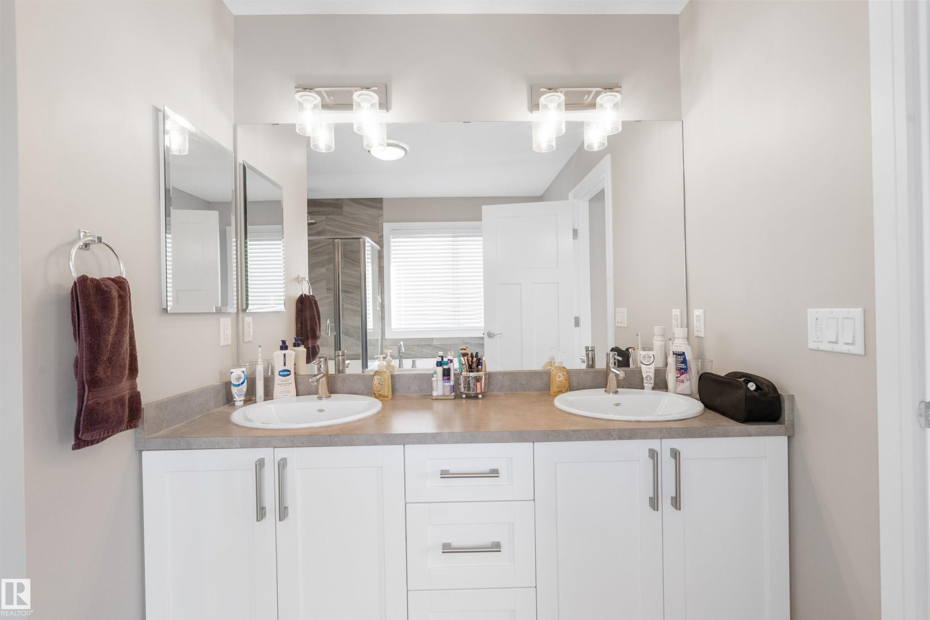 Dual vanity with undermount sinks, white cabinetry, and brushed nickel hardware - 3334 Parker Loop Sw, Edmonton, AB