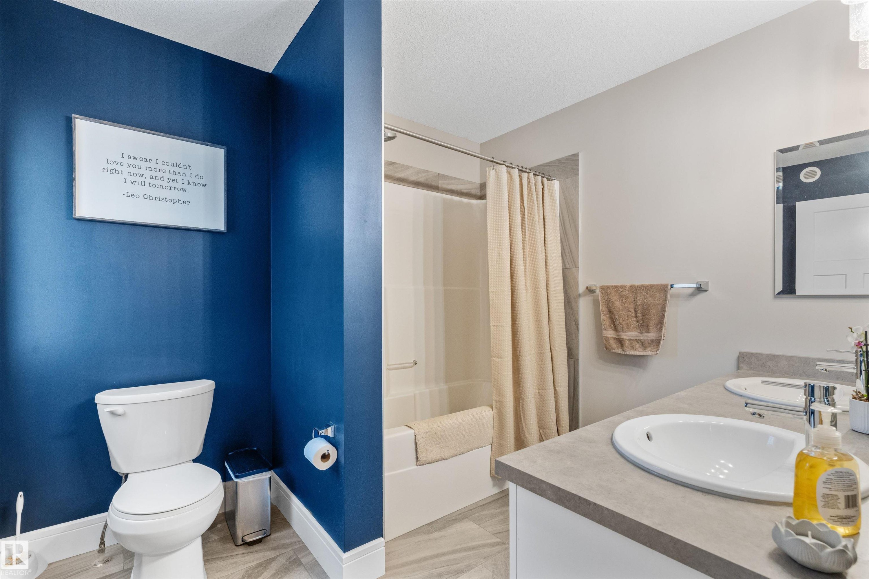 Bathroom featuring a dual vanity with undermount sinks, a combination shower and tub, and light-toned flooring - 3334 Parker Loop Sw, Edmonton, AB