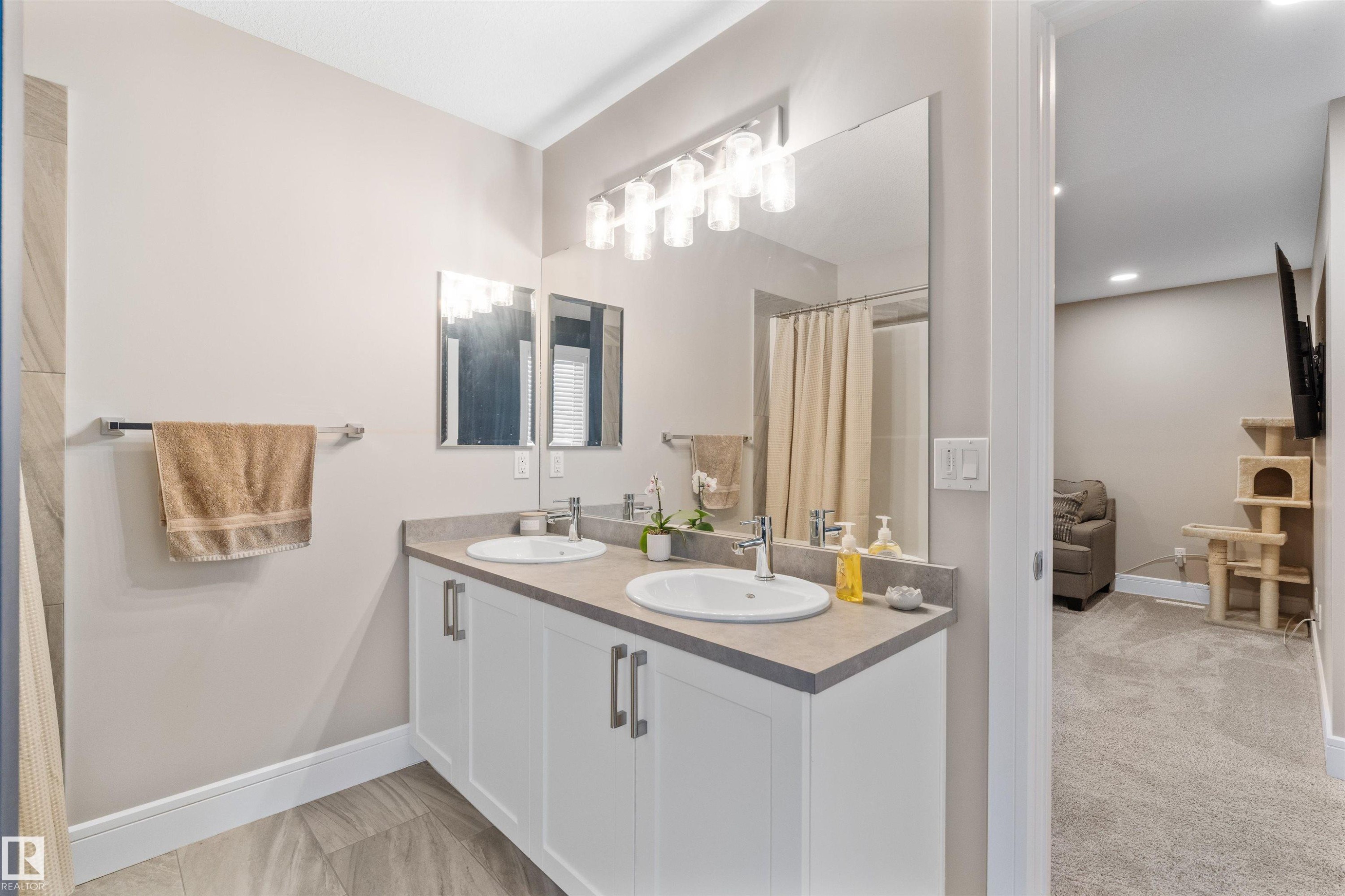 Double vanity with white cabinetry, light countertops, and individual undermount sinks - 3334 Parker Loop Sw, Edmonton, AB