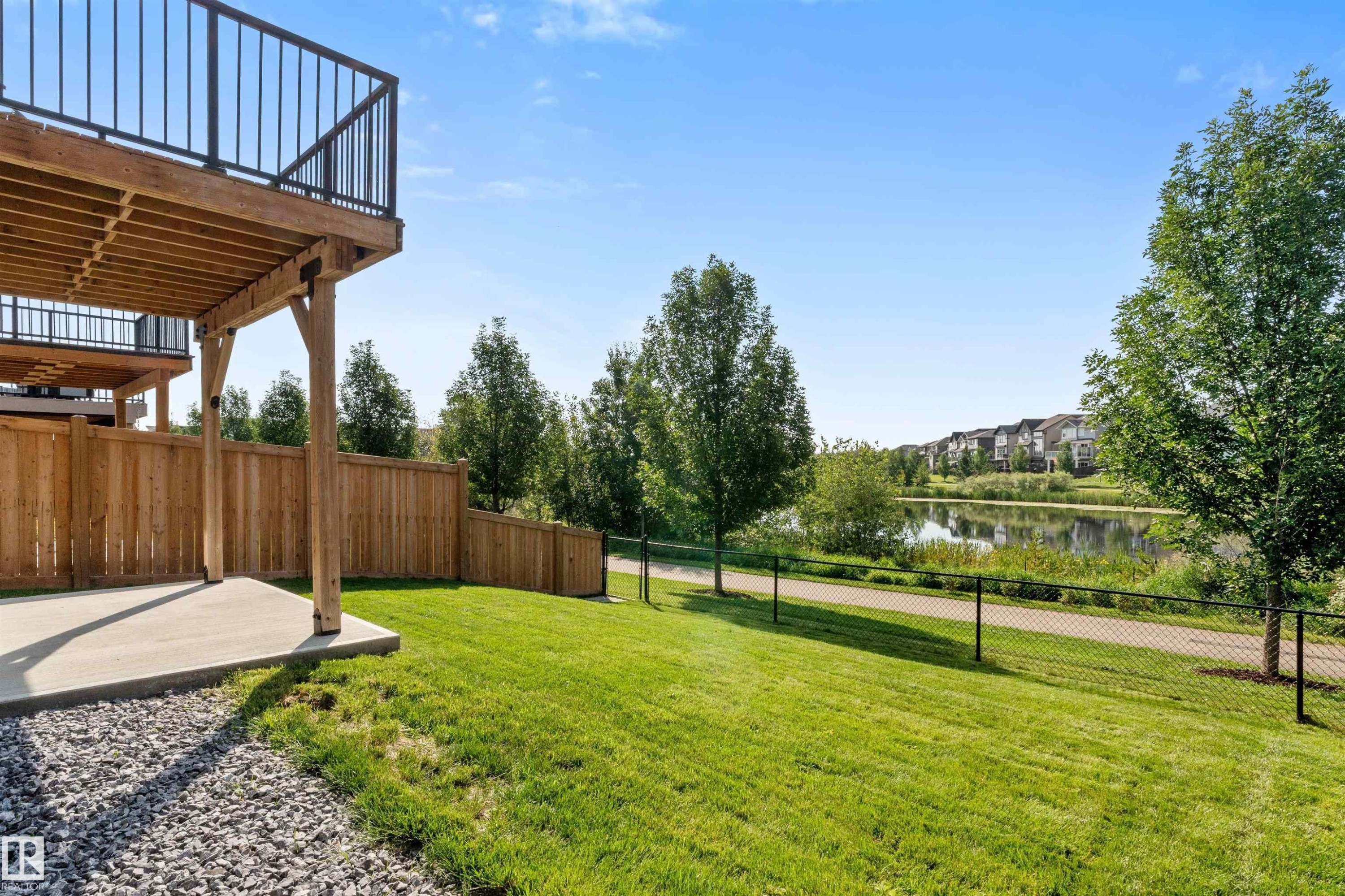 Ground-level concrete patio with a wood privacy fence - 3334 Parker Loop Sw, Edmonton, AB