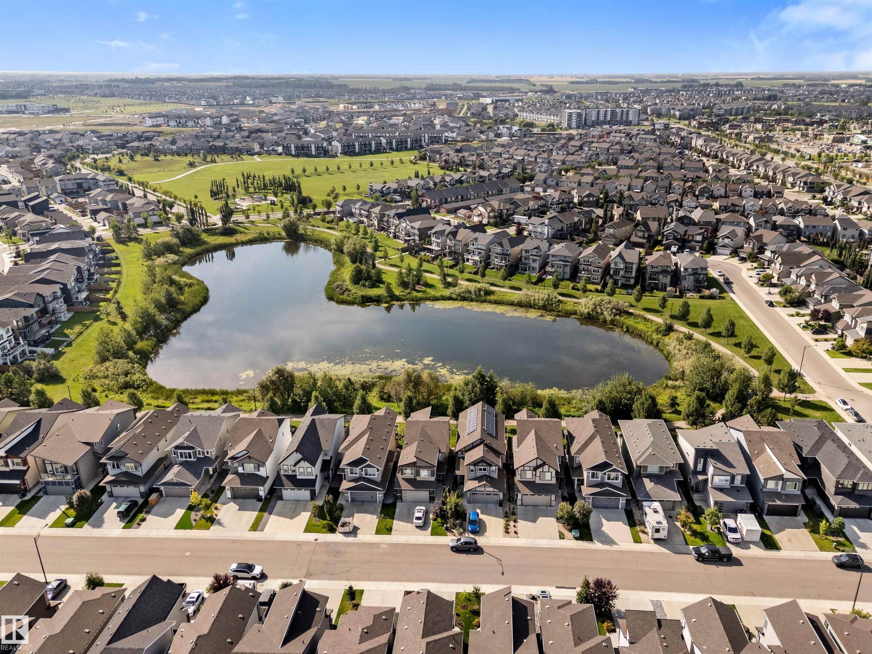 Neighborhood featuring a large pond surrounded by green spaces and residential properties - 3334 Parker Loop Sw, Edmonton, AB