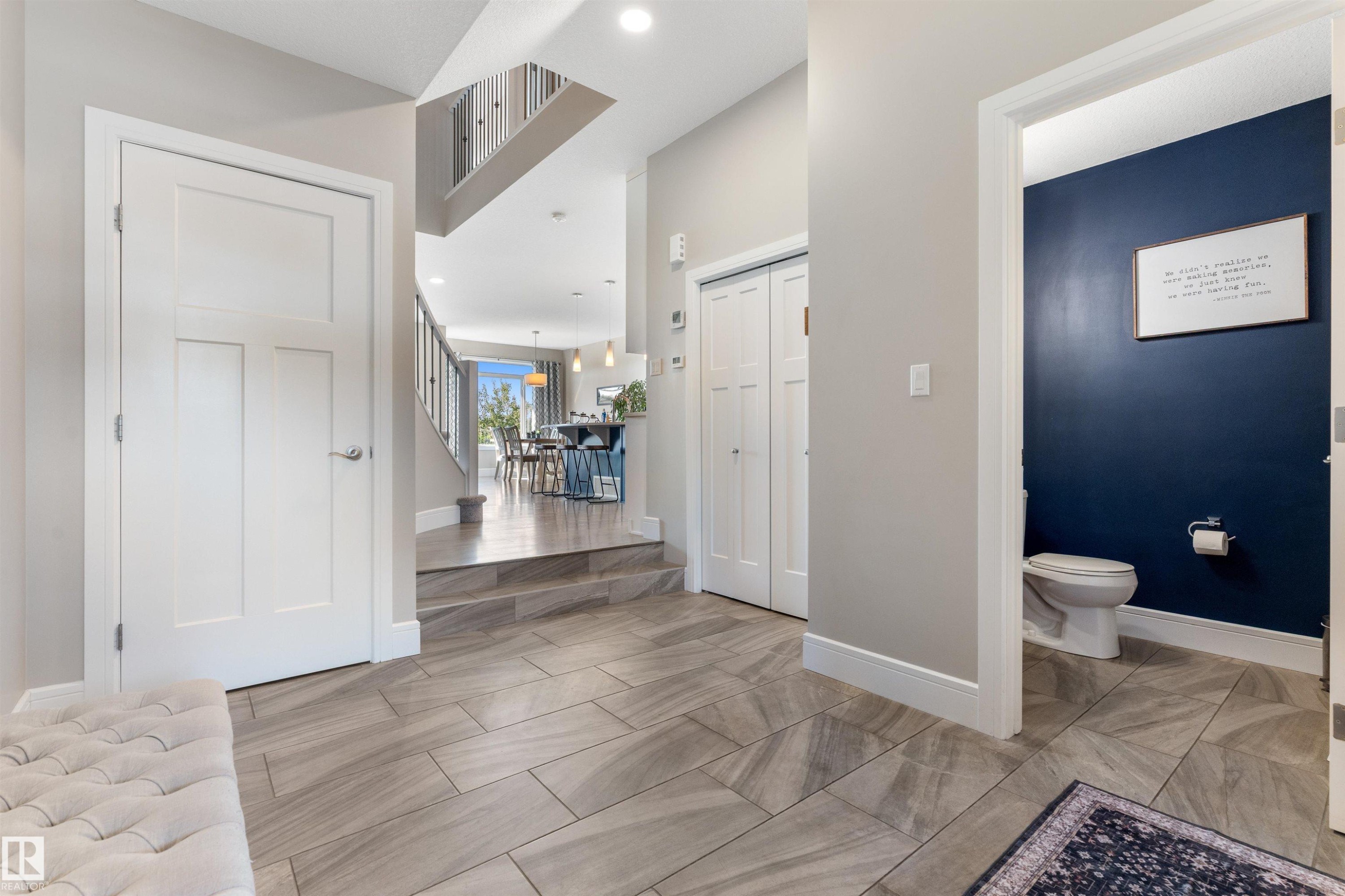 Light-toned tile flooring, white interior doors, and a built-in closet with bifold doors - 3334 Parker Loop Sw, Edmonton, AB