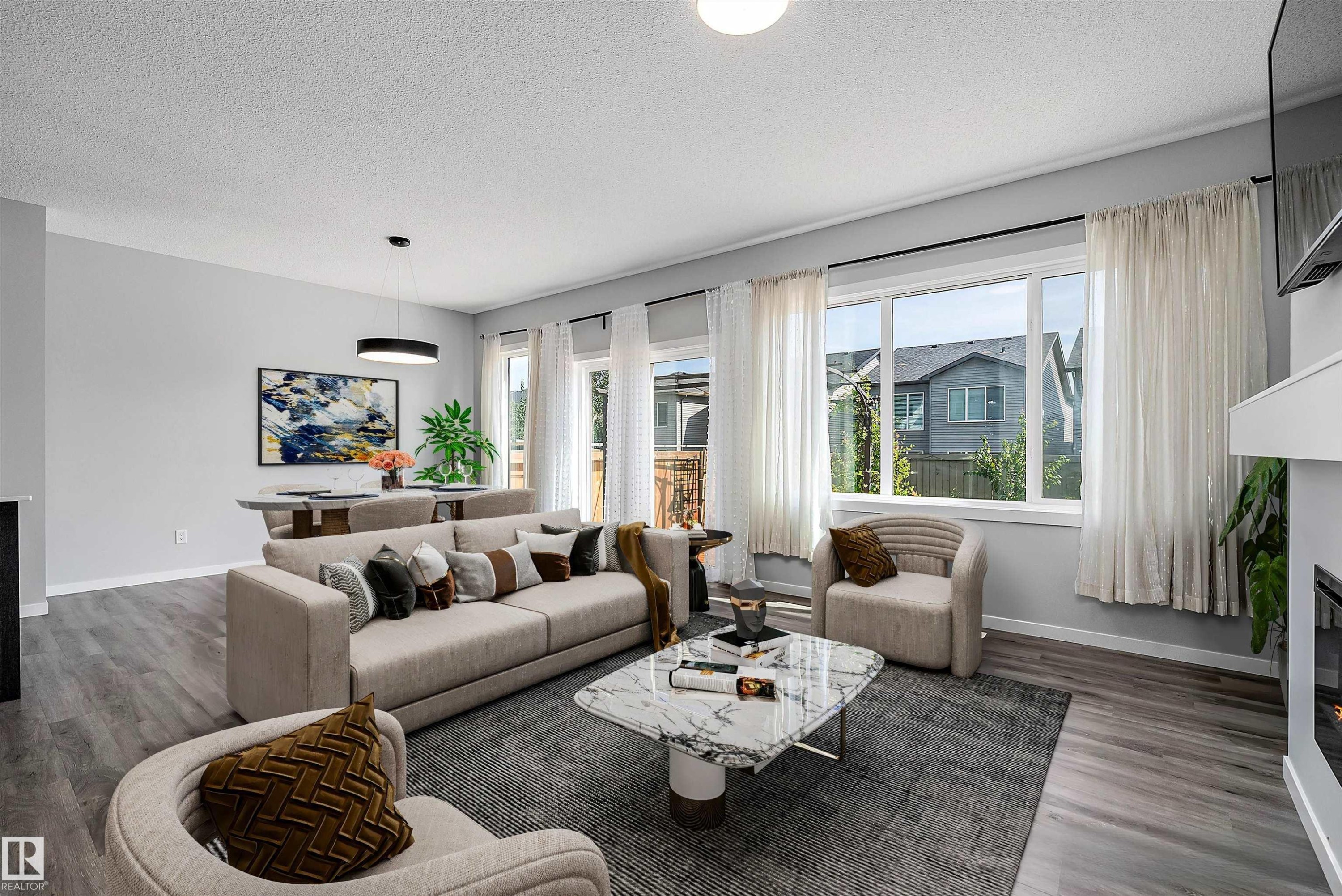 Expansive living area with wood-finish flooring, large windows, and a built-in fireplace - 9227 223 Street Nw, Edmonton, AB