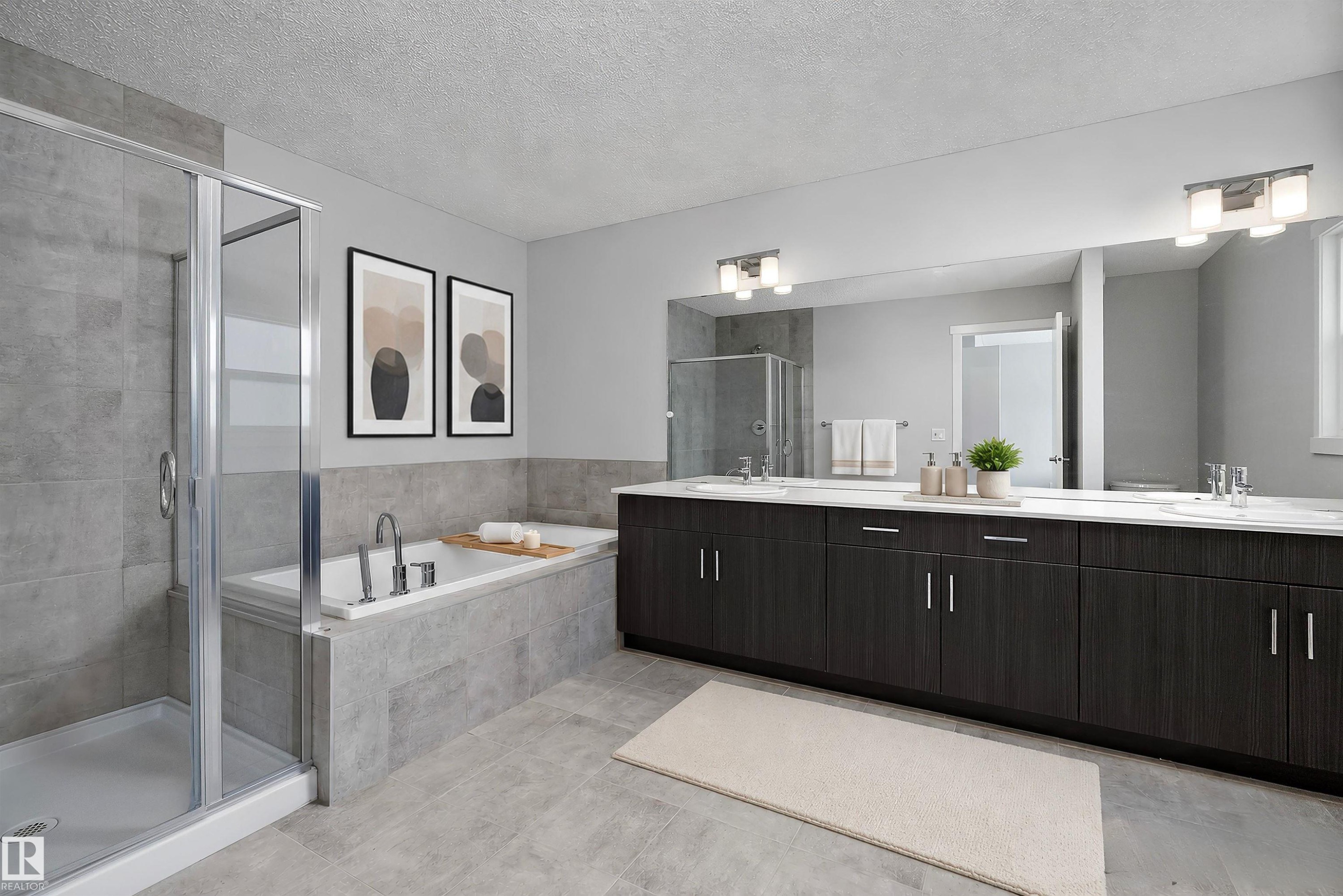 Tiled walk-in shower with glass enclosure, separate soaking tub, expansive dual vanity with integrated sinks, full-width mirror, and overhead vanity lighting - 9227 223 Street Nw, Edmonton, AB