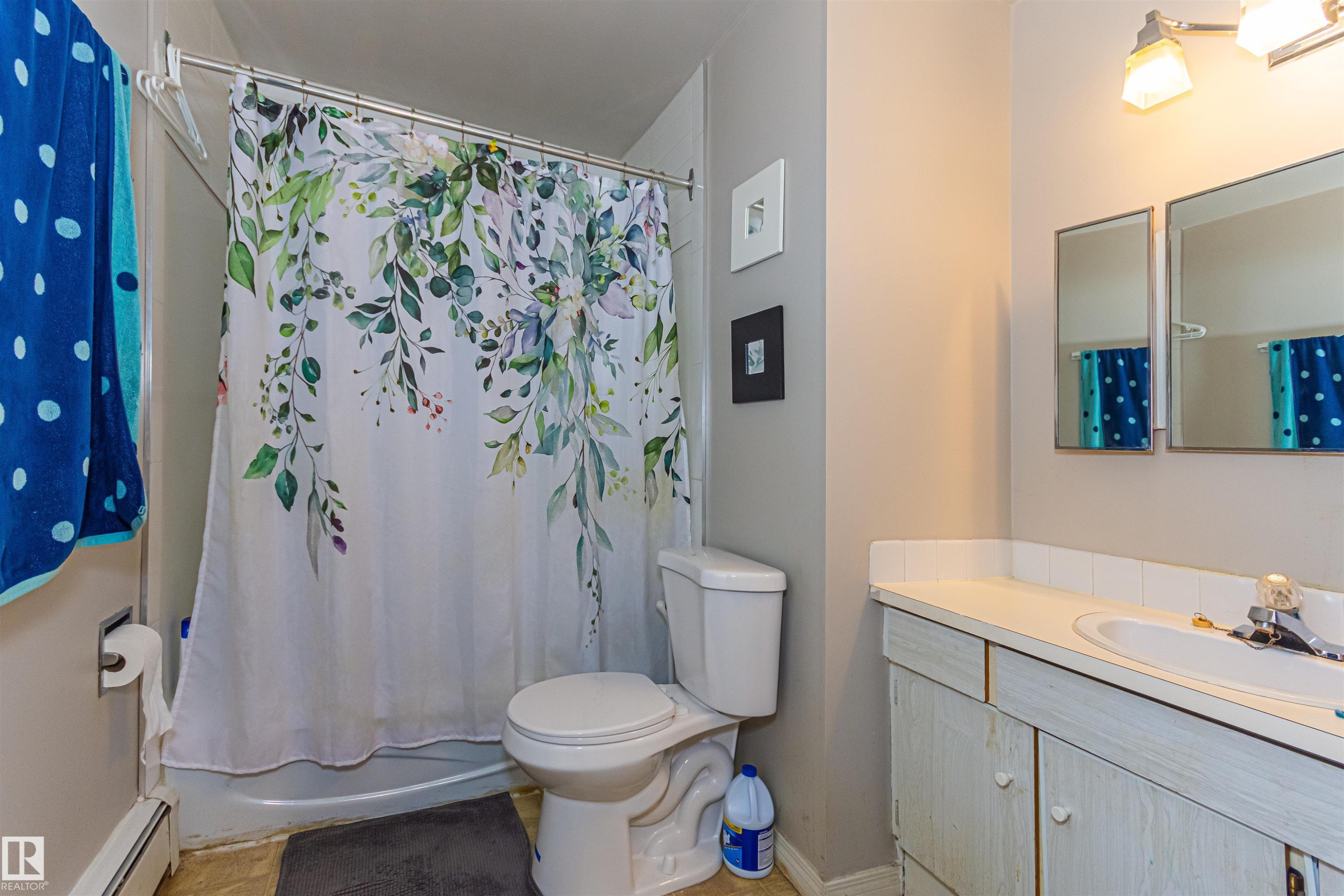 White vanity with an integrated sink and chrome faucet, accompanied by two rectangular mirrors - #6 3819 76 St Nw, Edmonton, AB