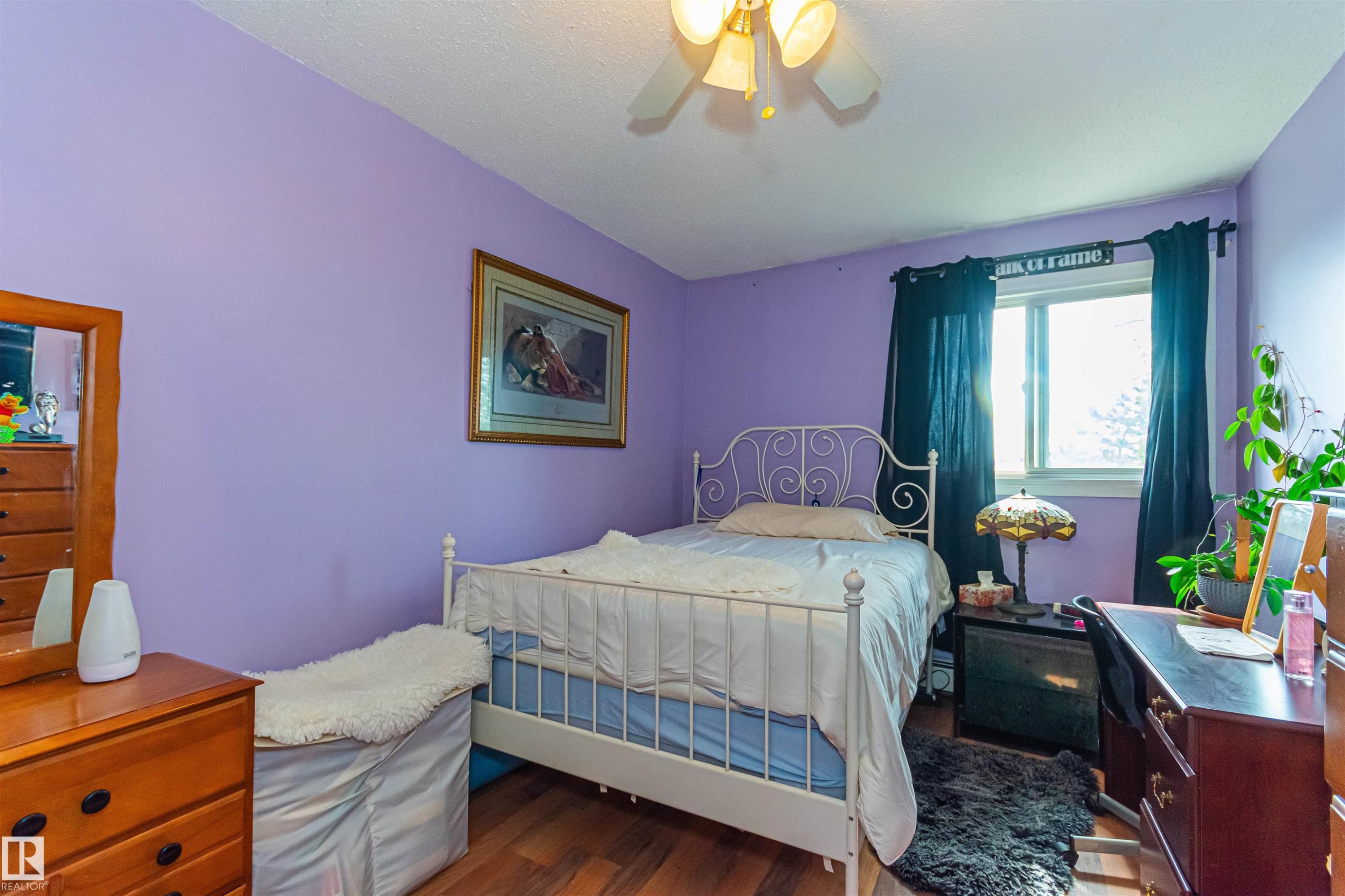 Wood-finish flooring throughout, bright window, and a ceiling fan with integrated lighting - #6 3819 76 St Nw, Edmonton, AB