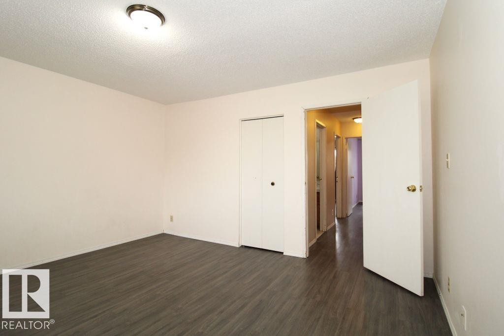 Wood-finish flooring, ceiling-mounted light fixture, and closet with bi-fold doors - 11393 22 Avenue Nw, Edmonton, AB