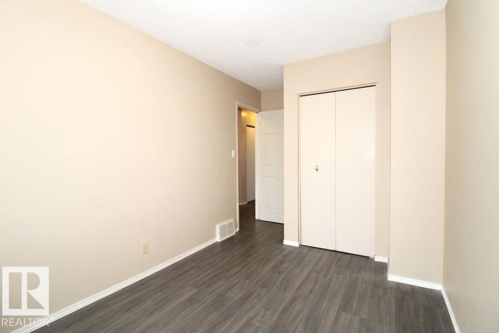 Wood-finish flooring, neutral wall paint, and white trim - 11393 22 Avenue Nw, Edmonton, AB