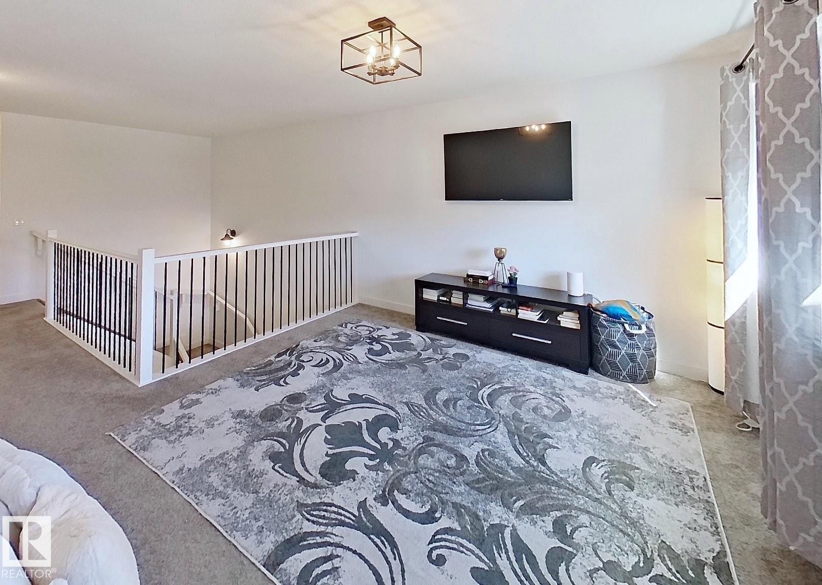 Staircase featuring white newel posts, white handrails, and black vertical balusters - 40 Jamison Crescent, St. Albert, AB