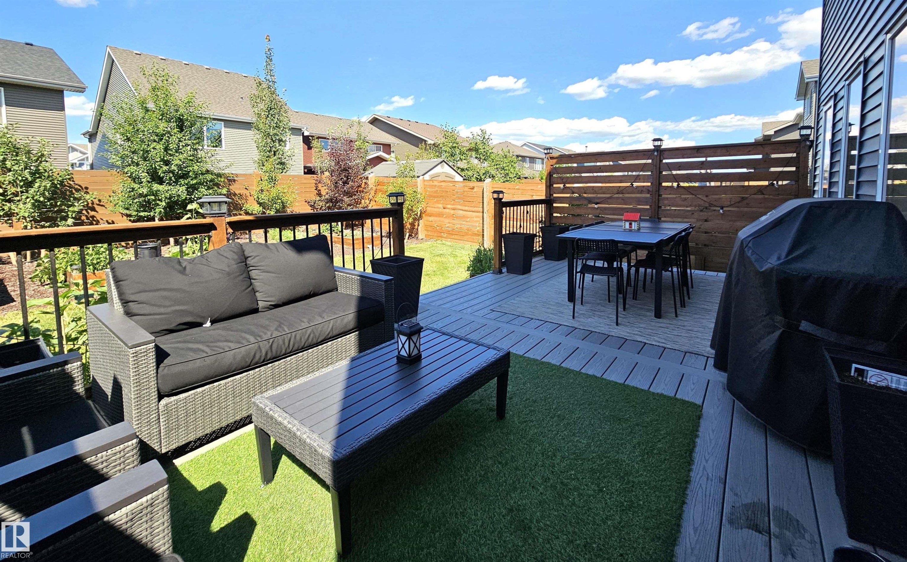 Expansive multi-level deck featuring composite decking, wood privacy screen, and artificial turf accent - 40 Jamison Crescent, St. Albert, AB