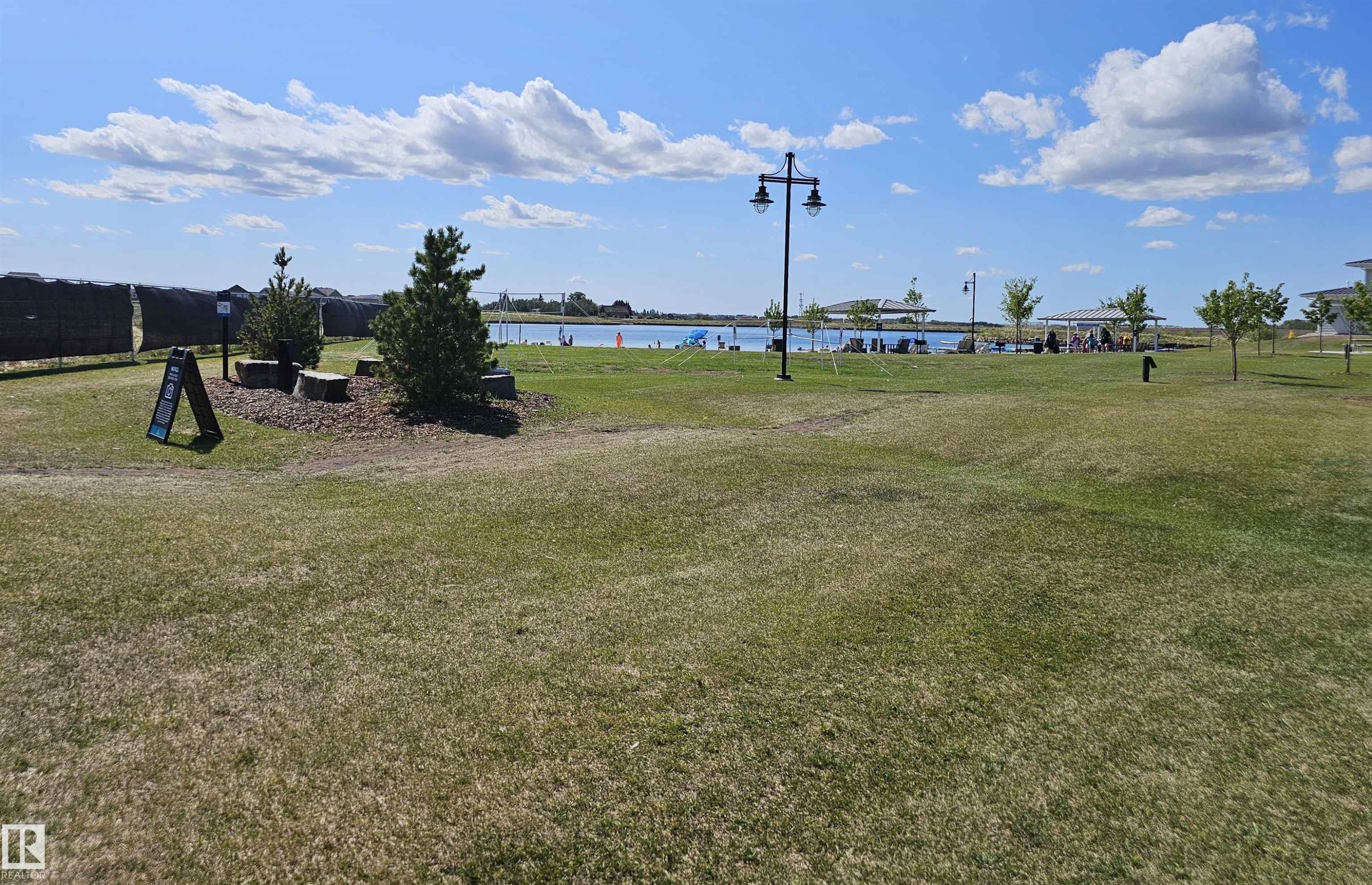 Expansive open green space with scattered trees and a distant body of water - 40 Jamison Crescent, St. Albert, AB