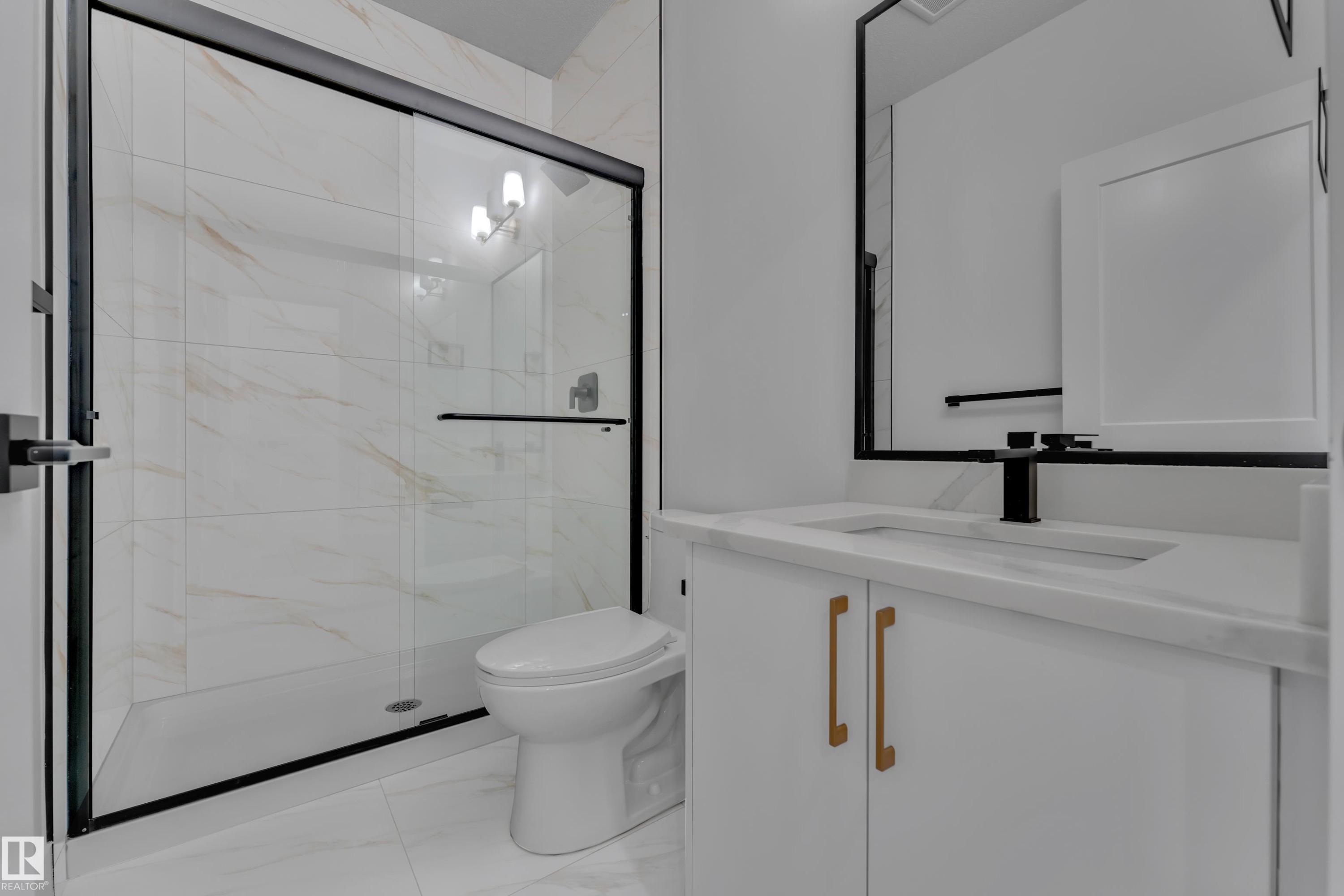 White vanity with gold-tone hardware, rectangular undermount sink, and black faucet - 178 Munn Way, Leduc, AB
