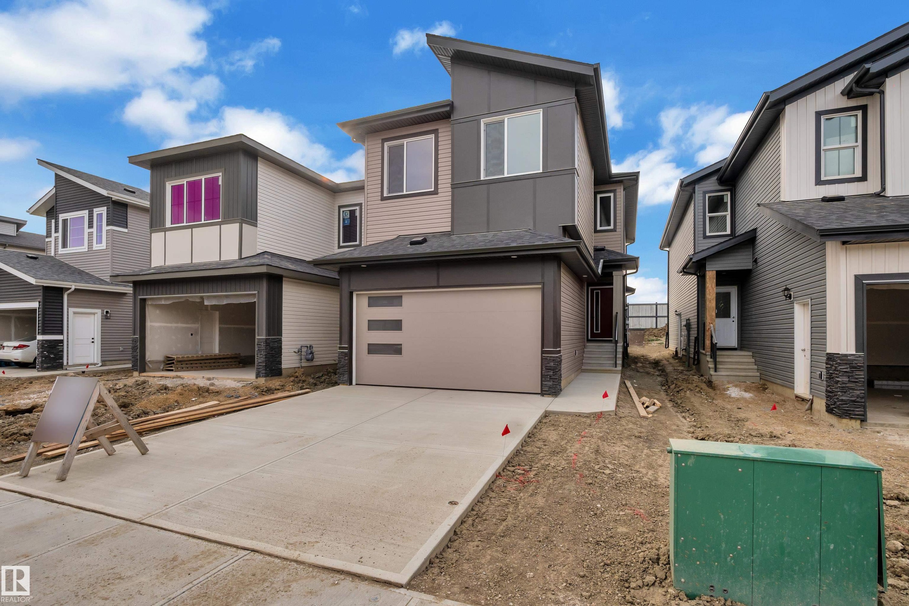 Modern exterior with clean lines, mixed siding, and stone accents - 178 Munn Way, Leduc, AB