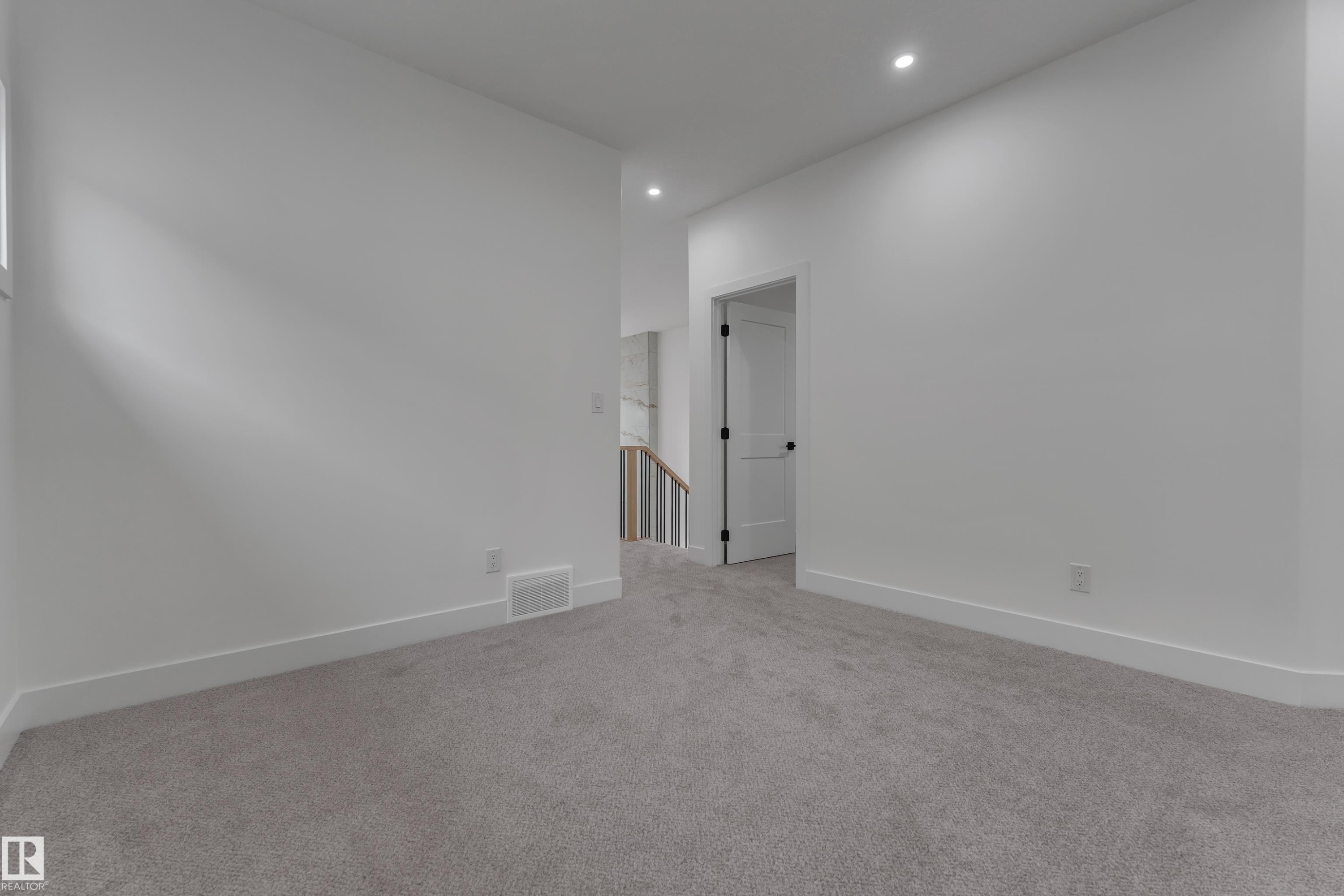 Recessed ceiling lighting, white walls, gray carpet flooring, white trim, and a white door with black hardware - 178 Munn Way, Leduc, AB