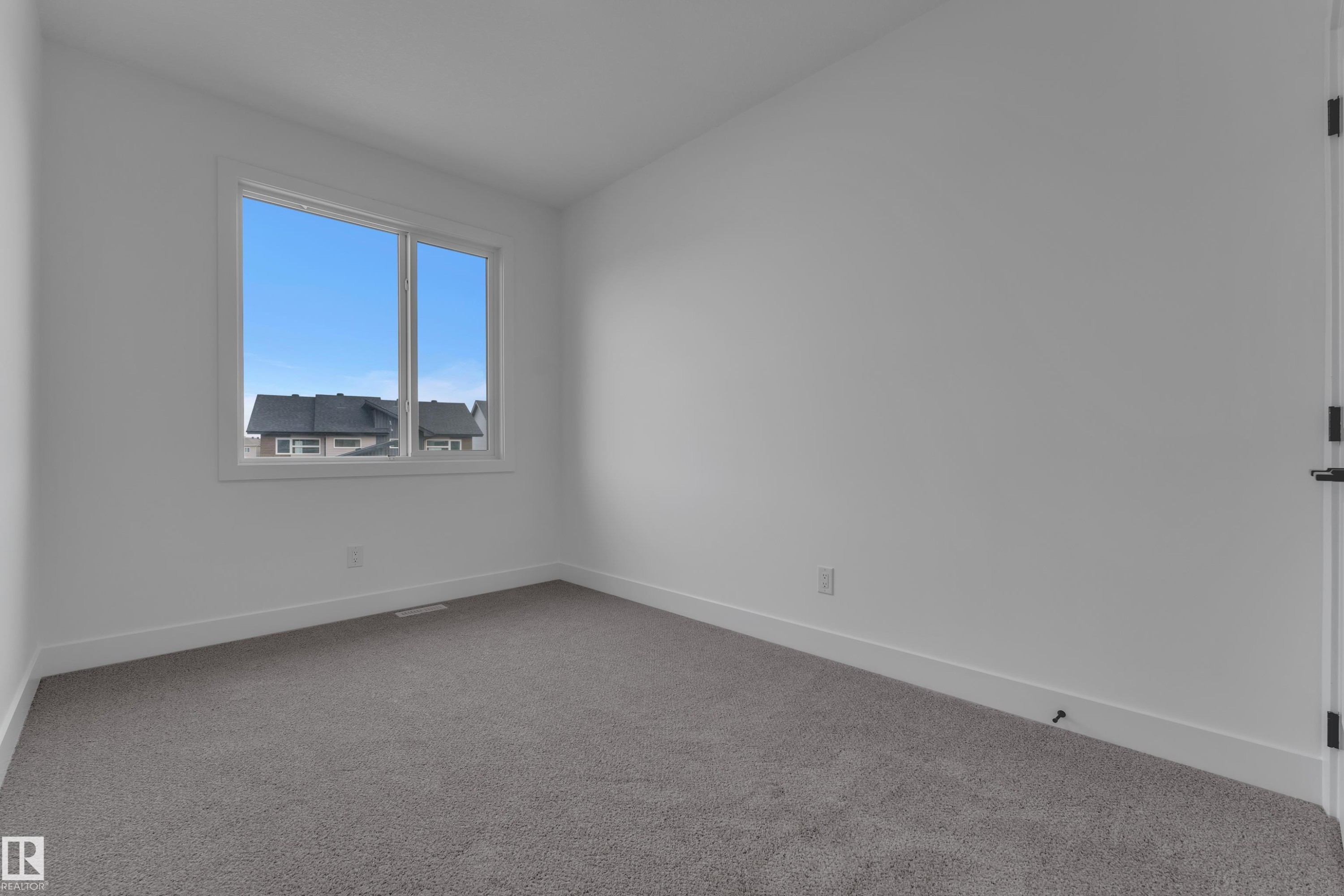 Neutral wall color, carpeted flooring, and a large window with white trim - 178 Munn Way, Leduc, AB