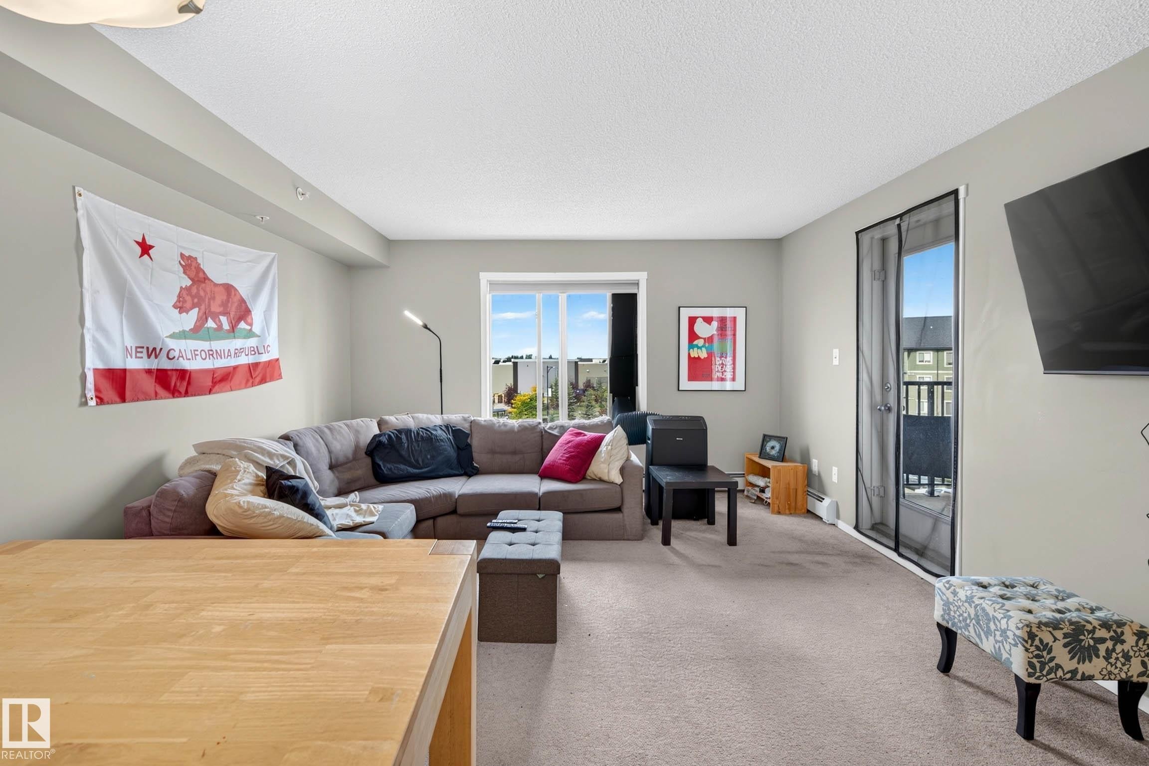 Neutral wall color with a large window and sliding glass door - #408 25 Element Dr, St. Albert, AB