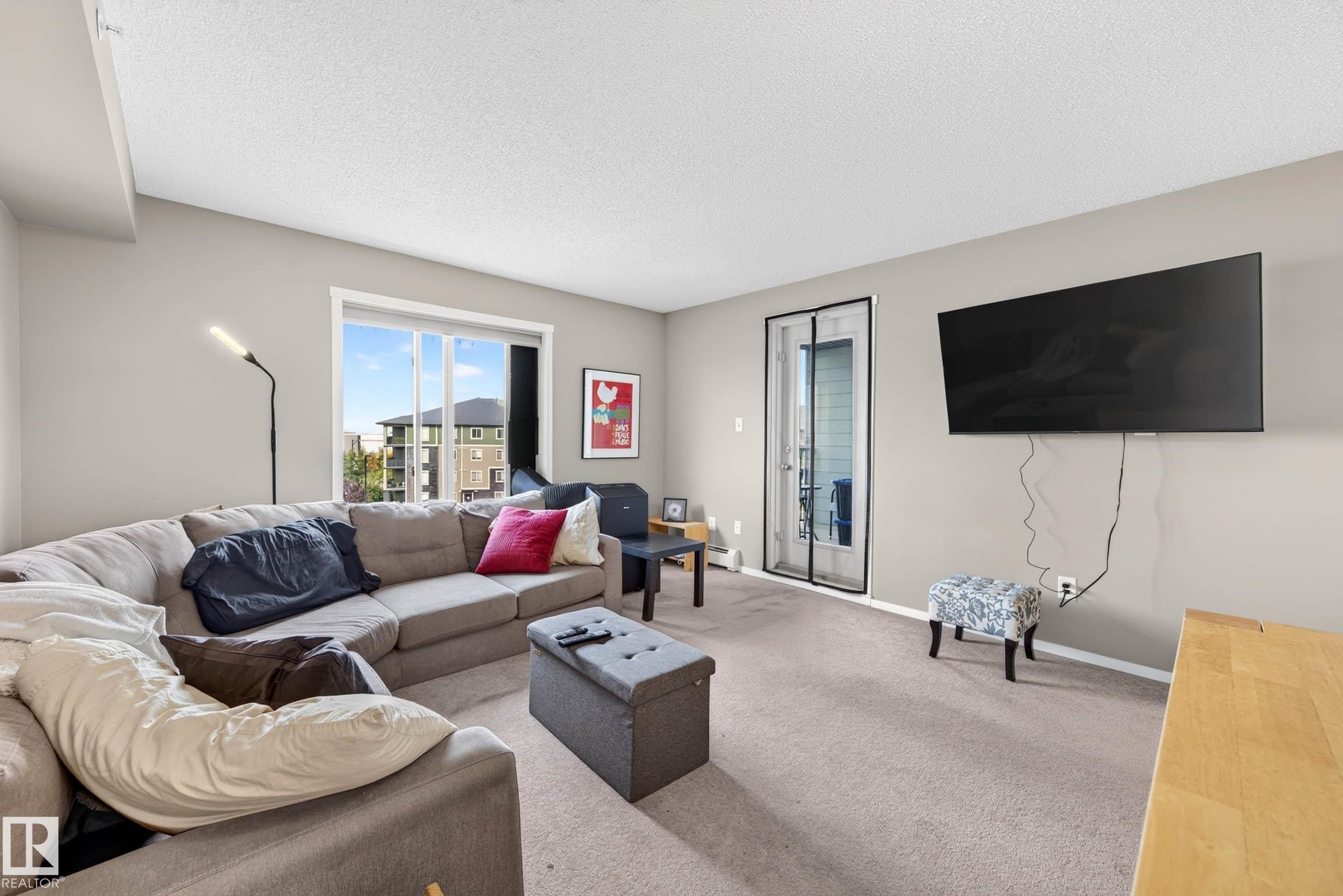Carpeted living area with light-toned walls - #408 25 Element Dr, St. Albert, AB