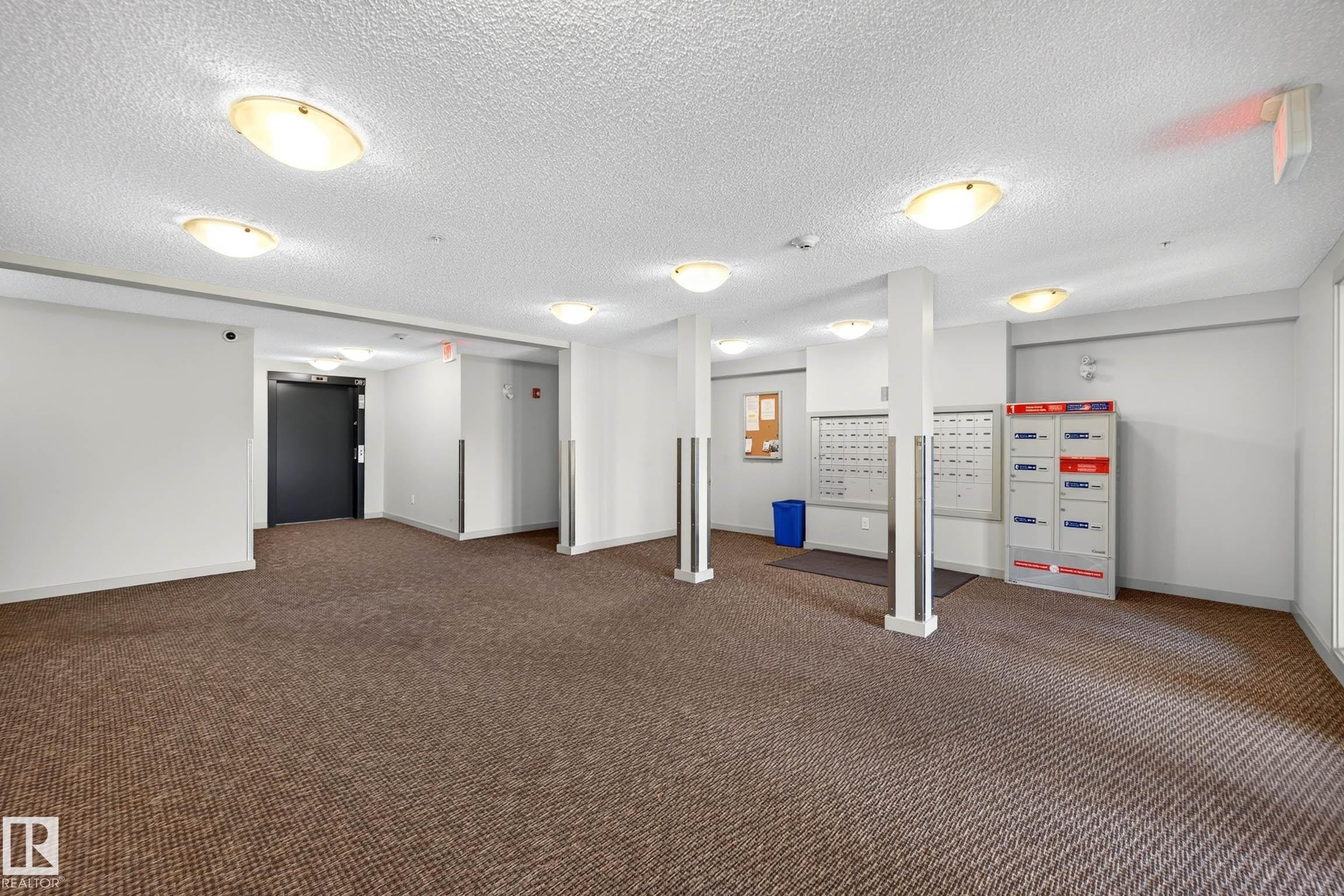 Mailroom with multiple individual mailboxes, overhead lighting, and carpeted flooring - #408 25 Element Dr, St. Albert, AB