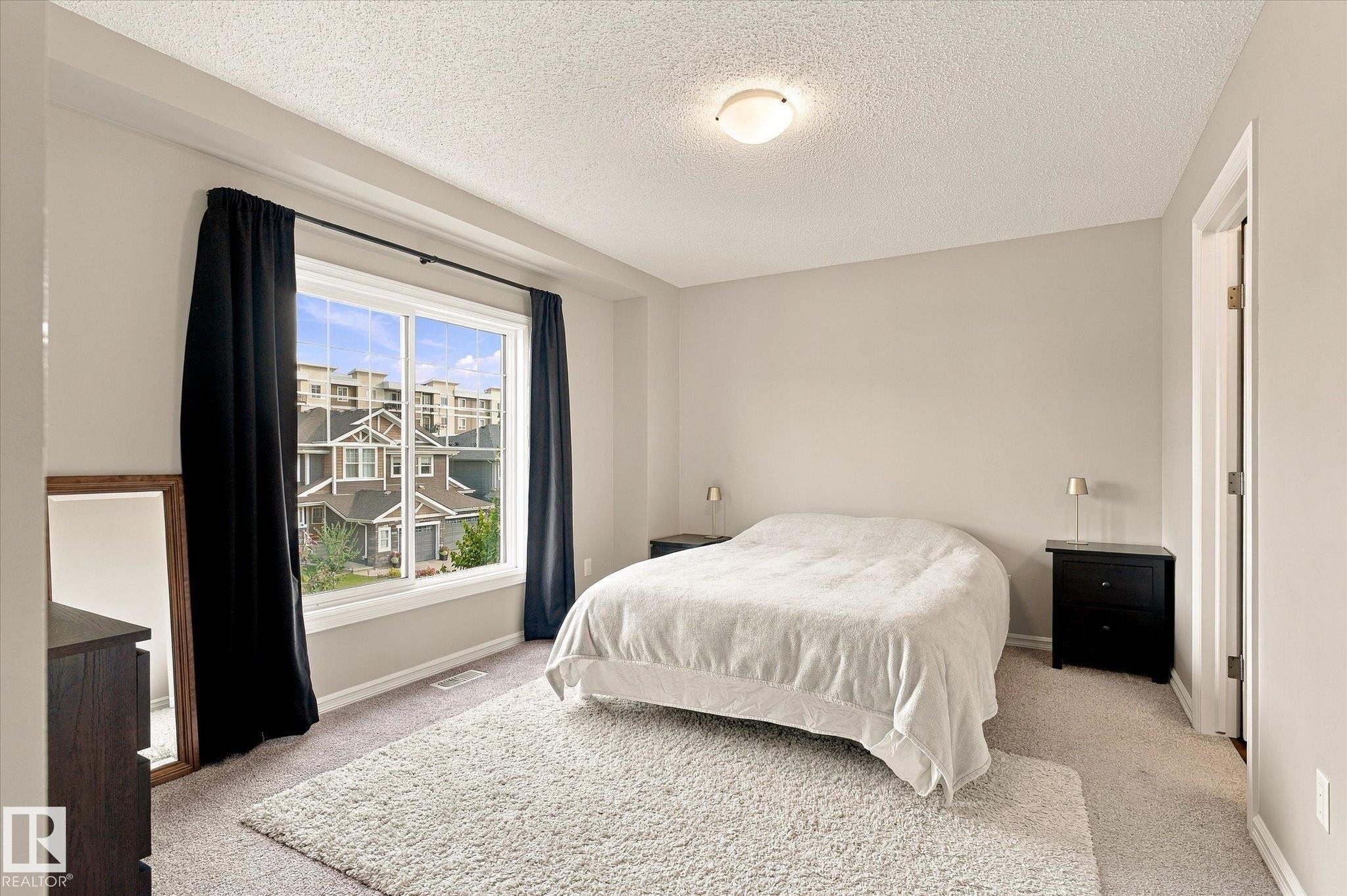 Wall-to-wall carpeting and a large window with black drapery - 21935 91 Avenue Nw, Edmonton, AB