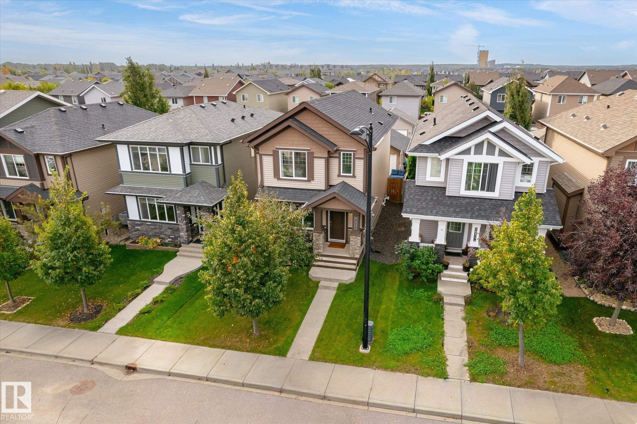 Contemporary two-story residence with a covered front porch, stone and siding exterior, and landscaped front yard - 21935 91 Avenue Nw, Edmonton, AB
